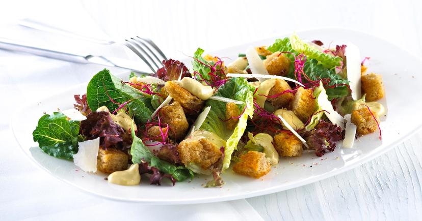 Blandet salat med krutonger og skivet parmesan.