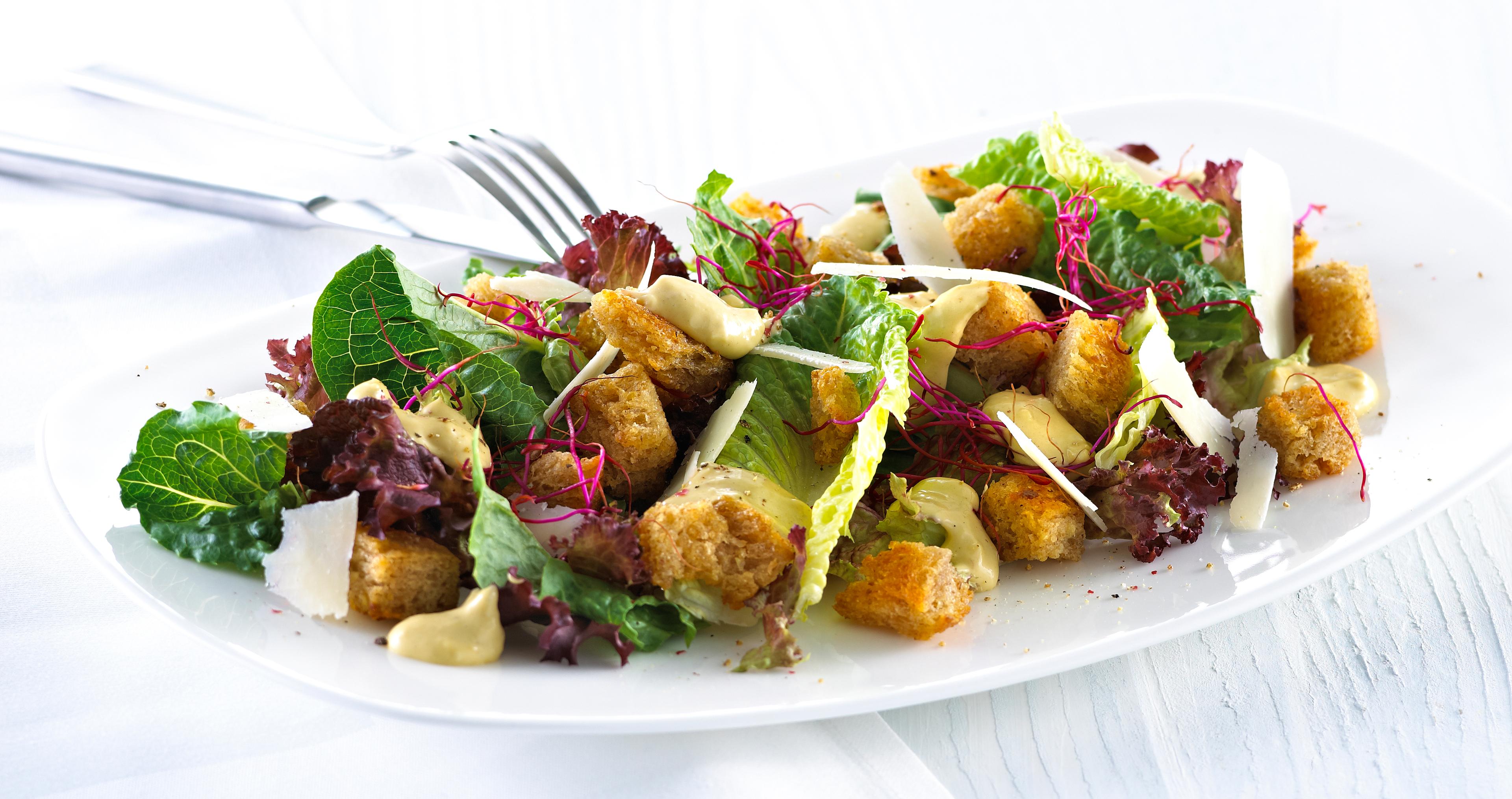 Blandet salat med krutonger og skivet parmesan.