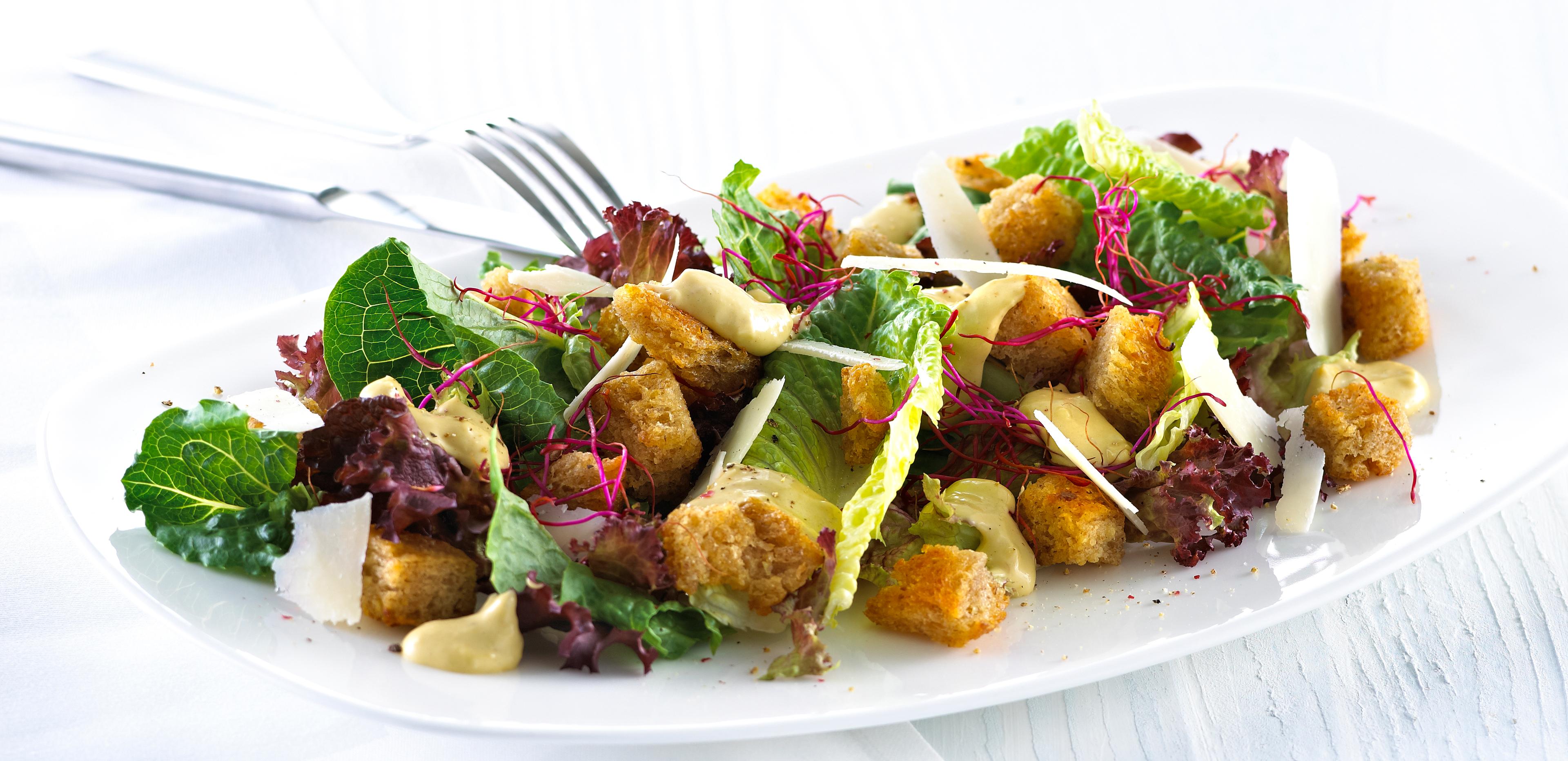 Blandet salat med krutonger og skivet parmesan.