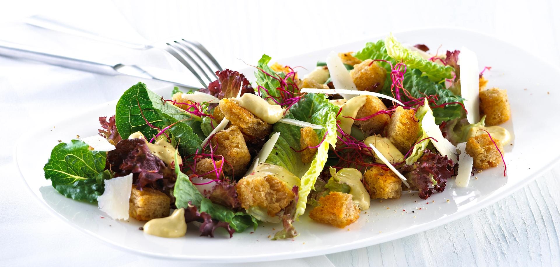 Blandet salat med krutonger og skivet parmesan.