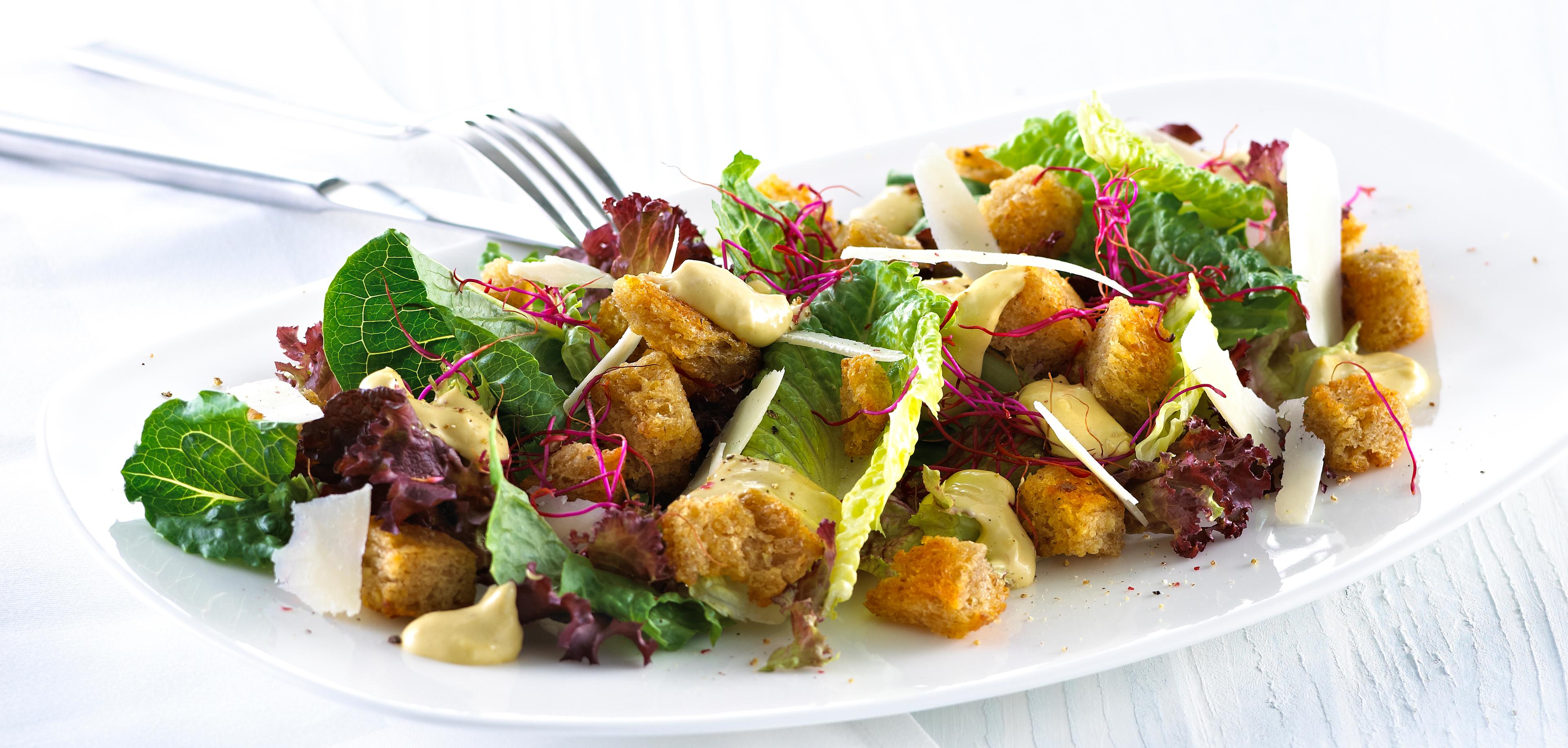 Blandet salat med krutonger og skivet parmesan.
