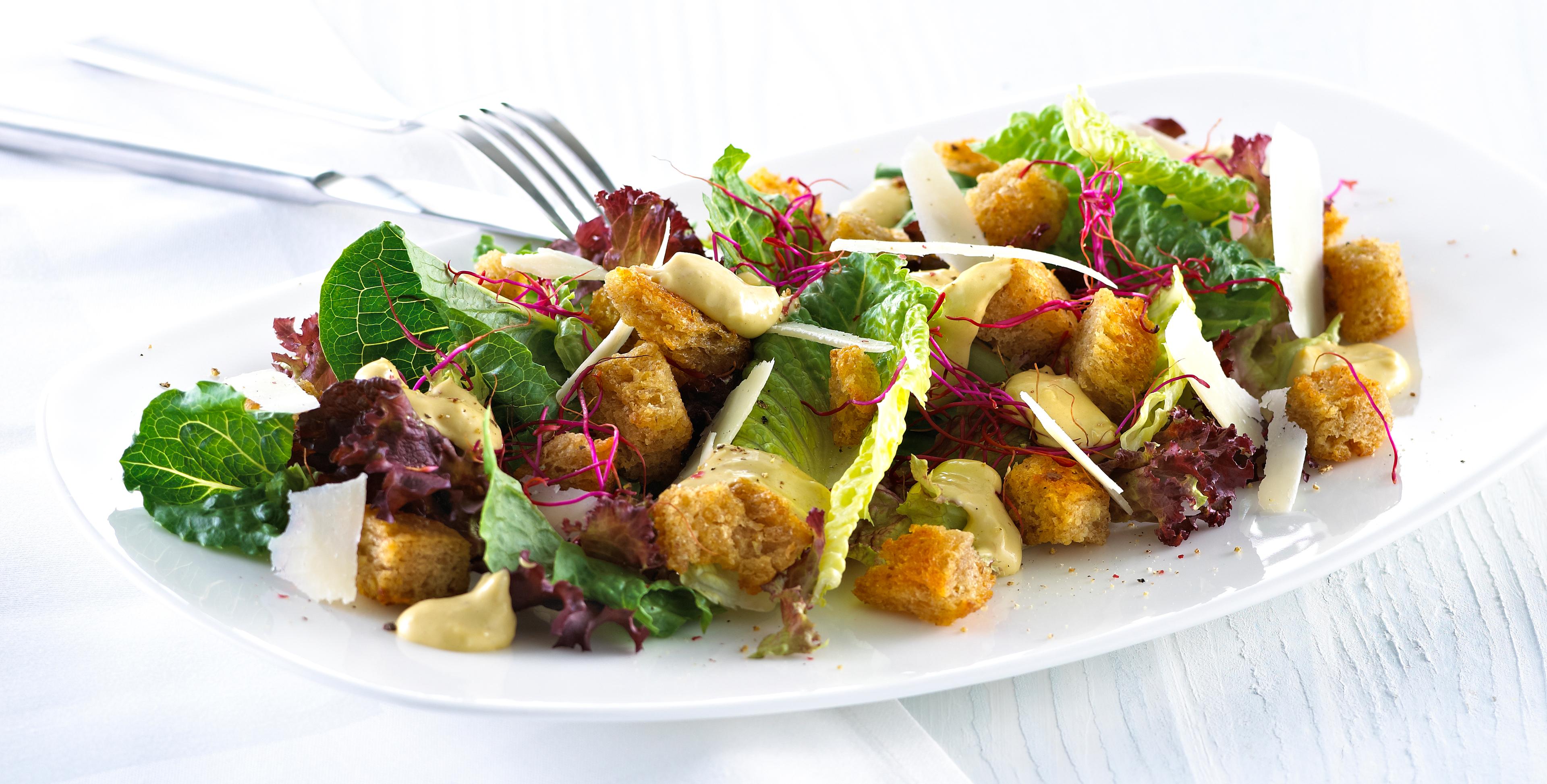 Blandet salat med krutonger og skivet parmesan.