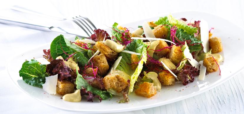 Blandet salat med krutonger og skivet parmesan.