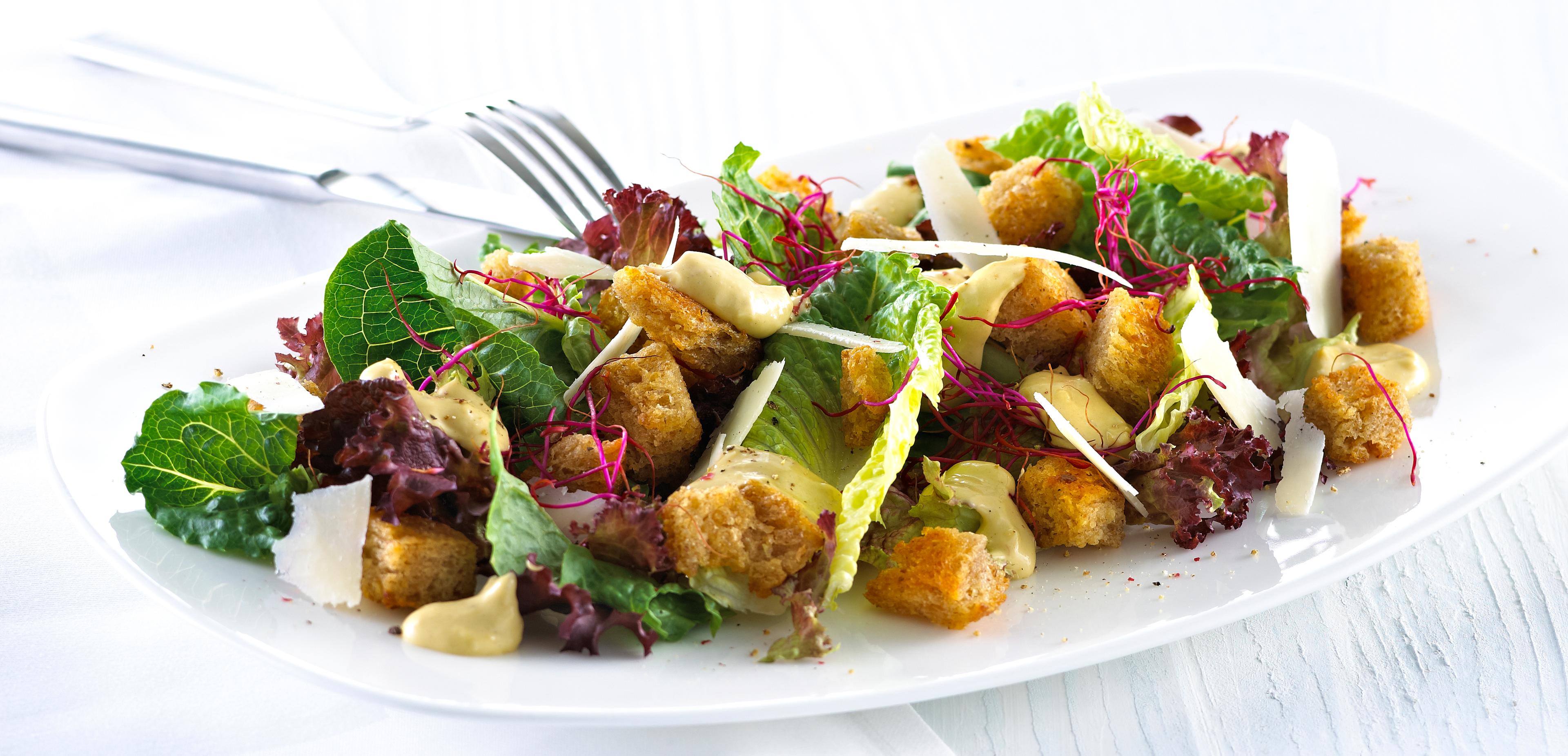 Blandet salat med krutonger og skivet parmesan.