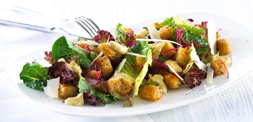 Blandet salat med krutonger og skivet parmesan.