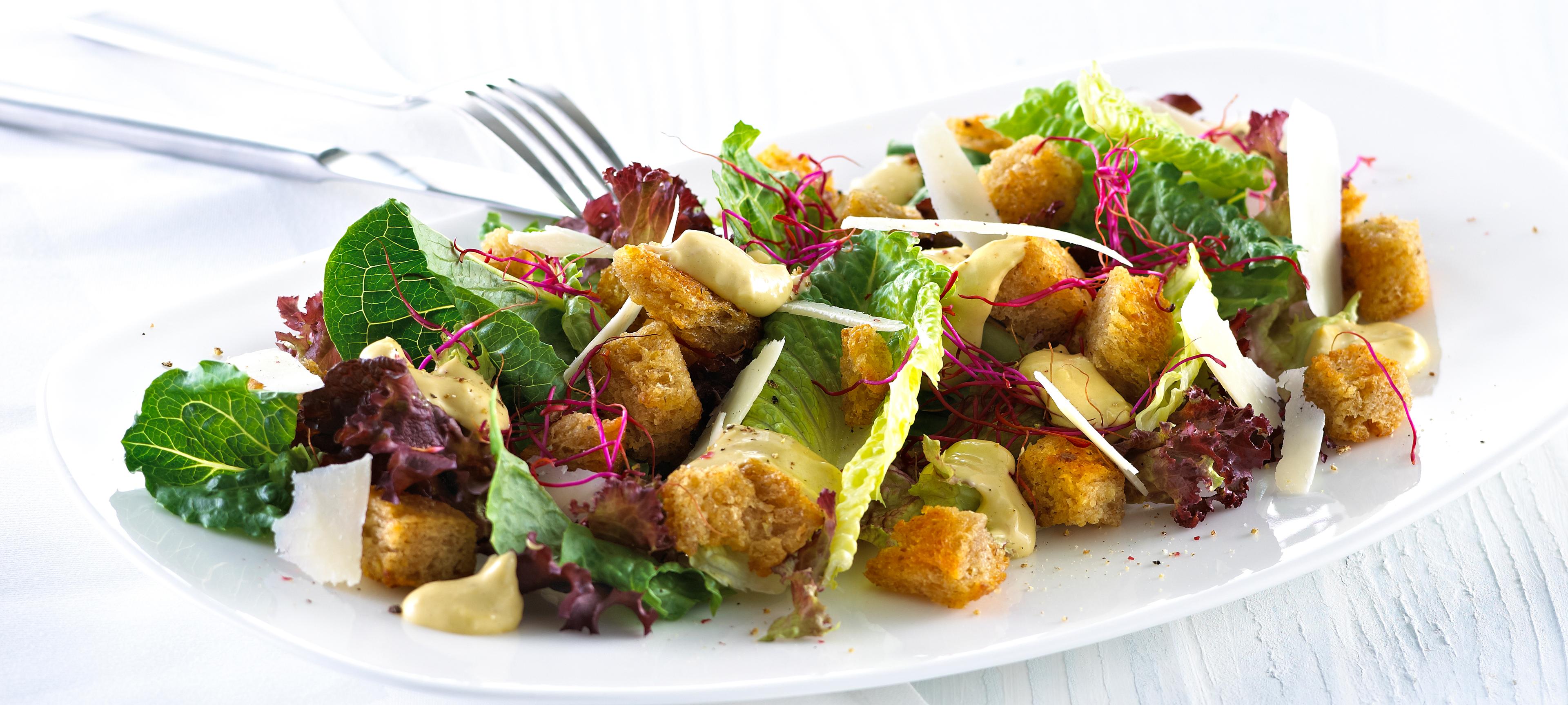 Blandet salat med krutonger og skivet parmesan.