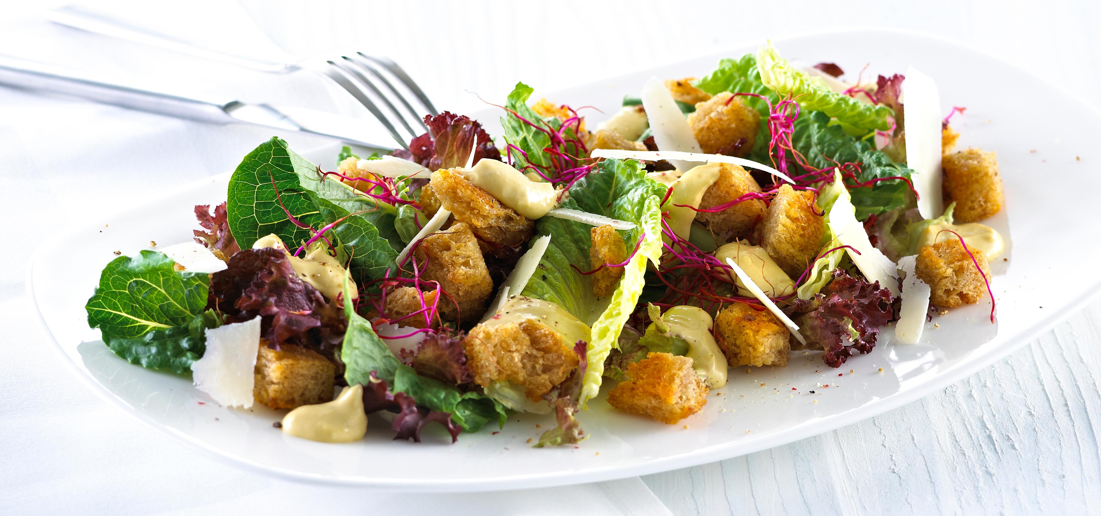 Blandet salat med krutonger og skivet parmesan.