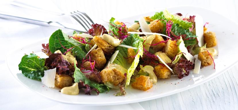 Blandet salat med krutonger og skivet parmesan.