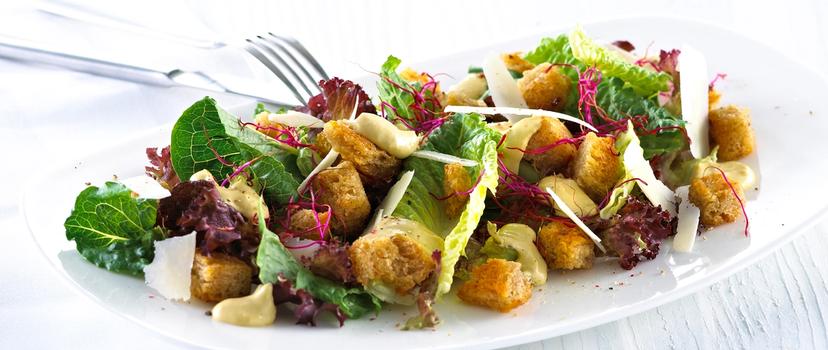 Blandet salat med krutonger og skivet parmesan.