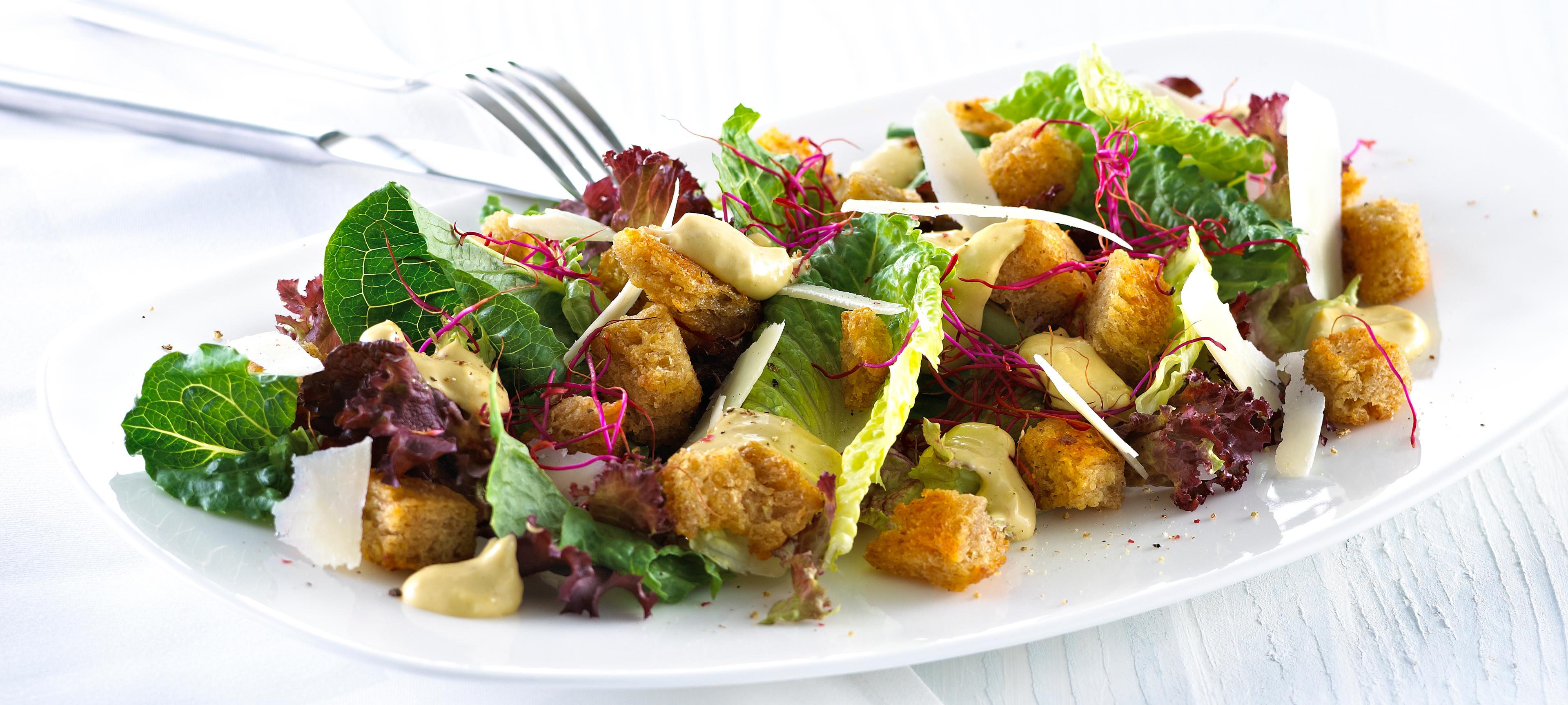 Blandet salat med krutonger og skivet parmesan.
