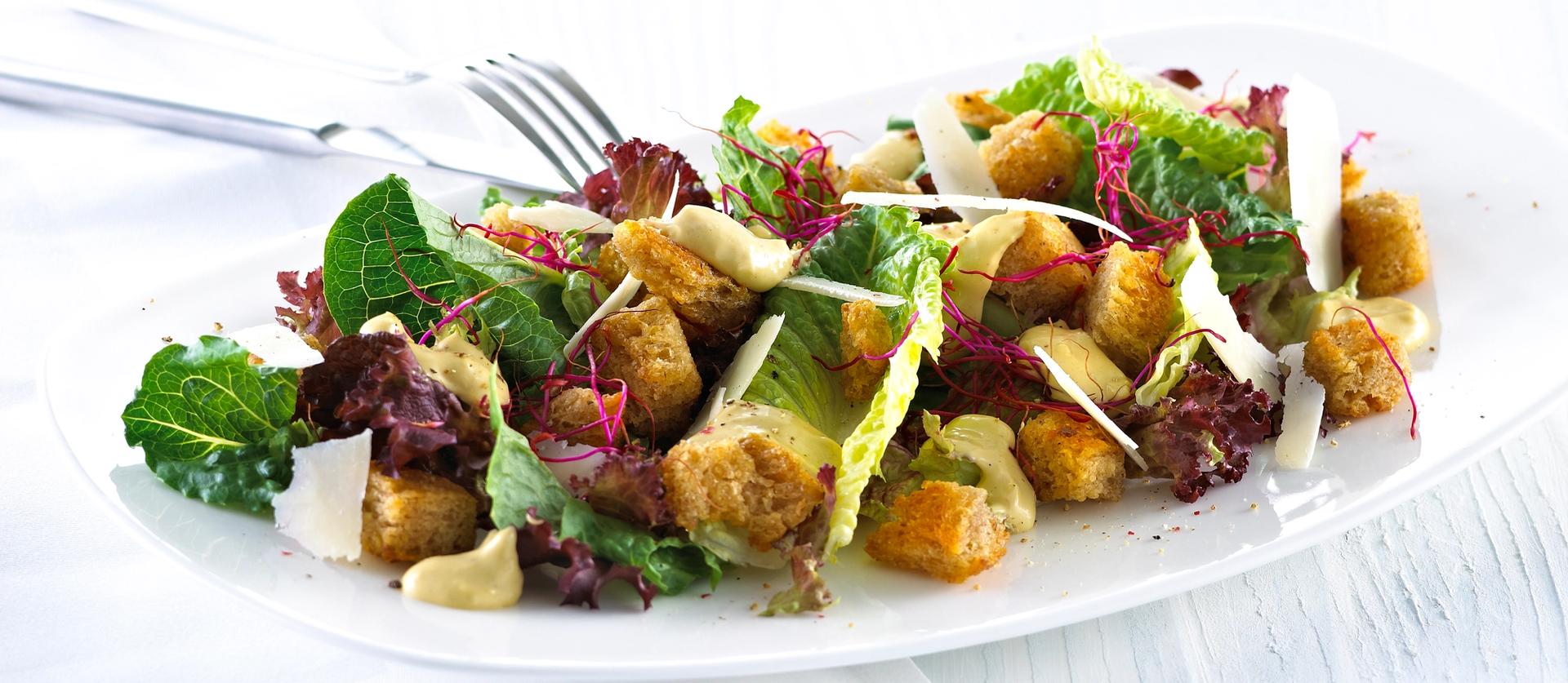 Blandet salat med krutonger og skivet parmesan.