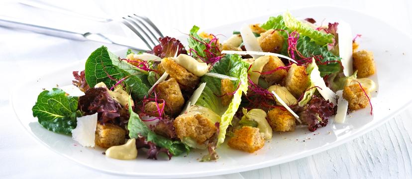 Blandet salat med krutonger og skivet parmesan.