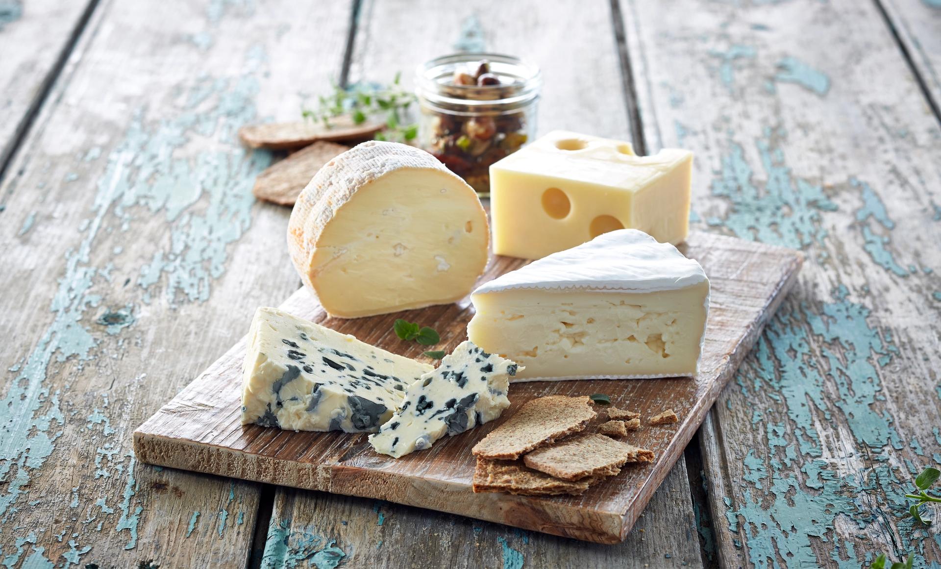 Trefat med fire forskjellige typer oster og kjeks.