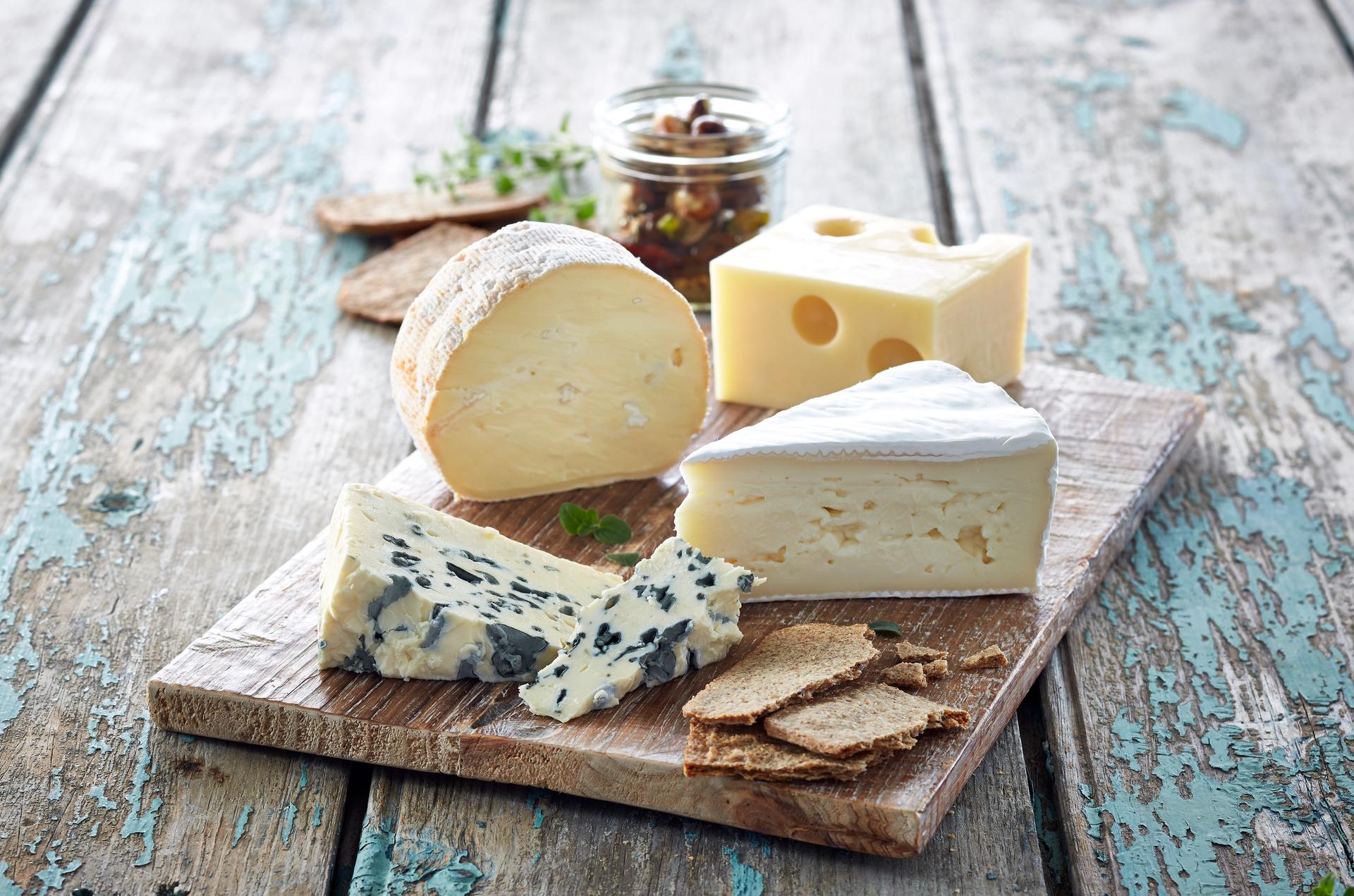 Trefat med fire forskjellige typer oster og kjeks.