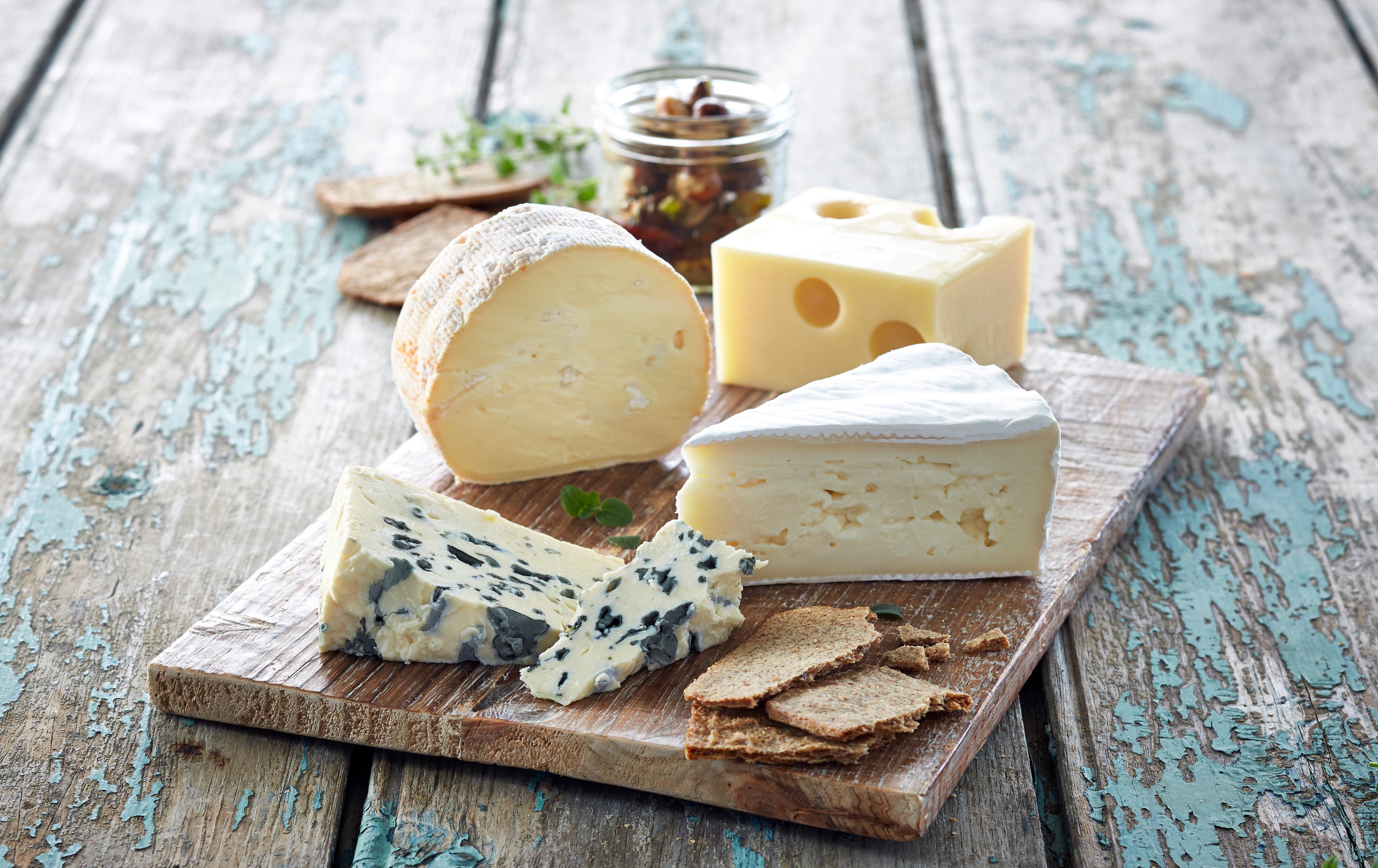 Trefat med fire forskjellige typer oster og kjeks.