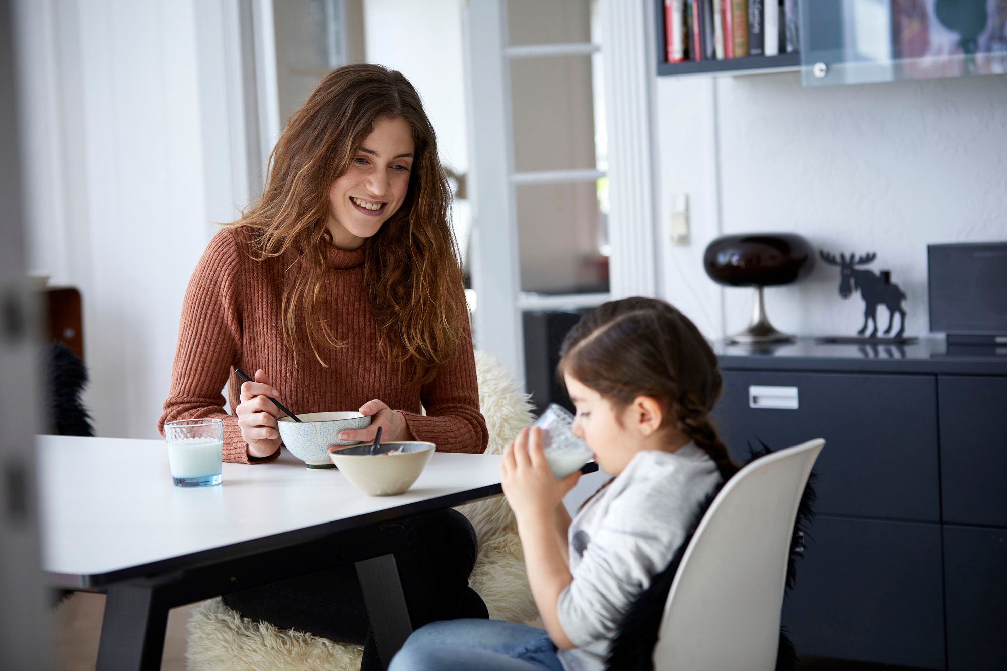 Mor med musliskål og datter med melkeglass