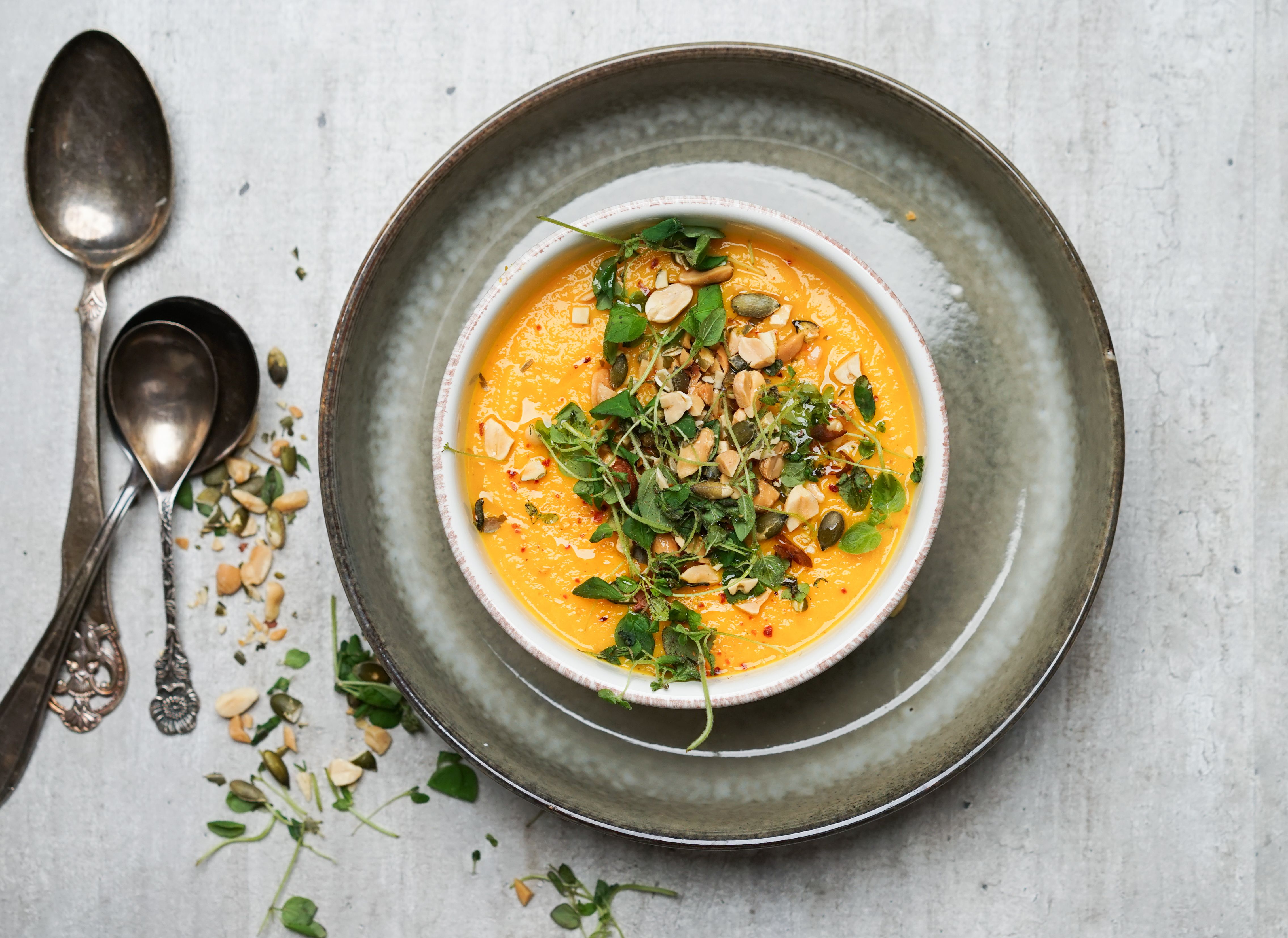 Tallerken med kremet gulrotsuppe med nøtter 