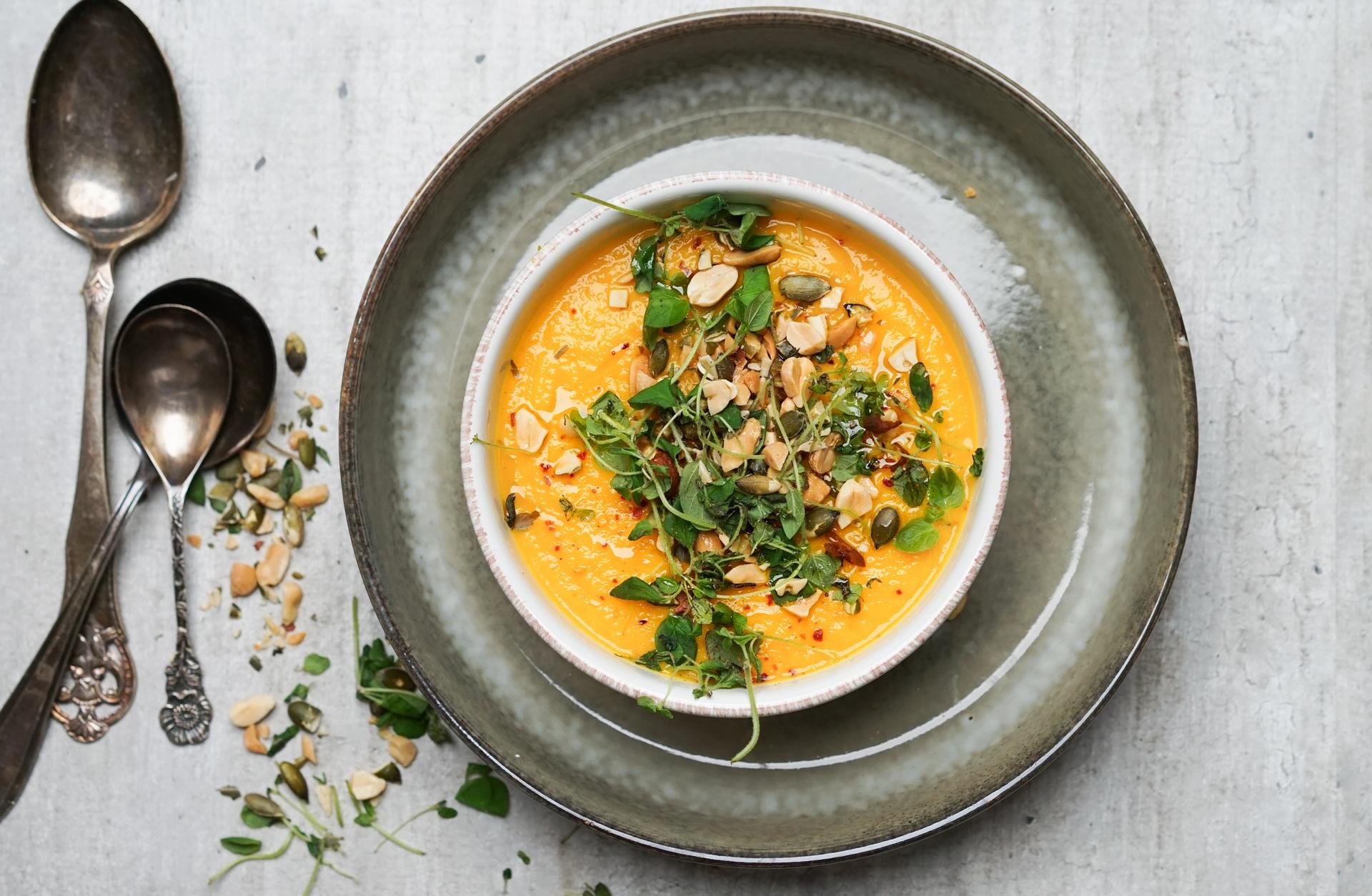 Tallerken med kremet gulrotsuppe med nøtter