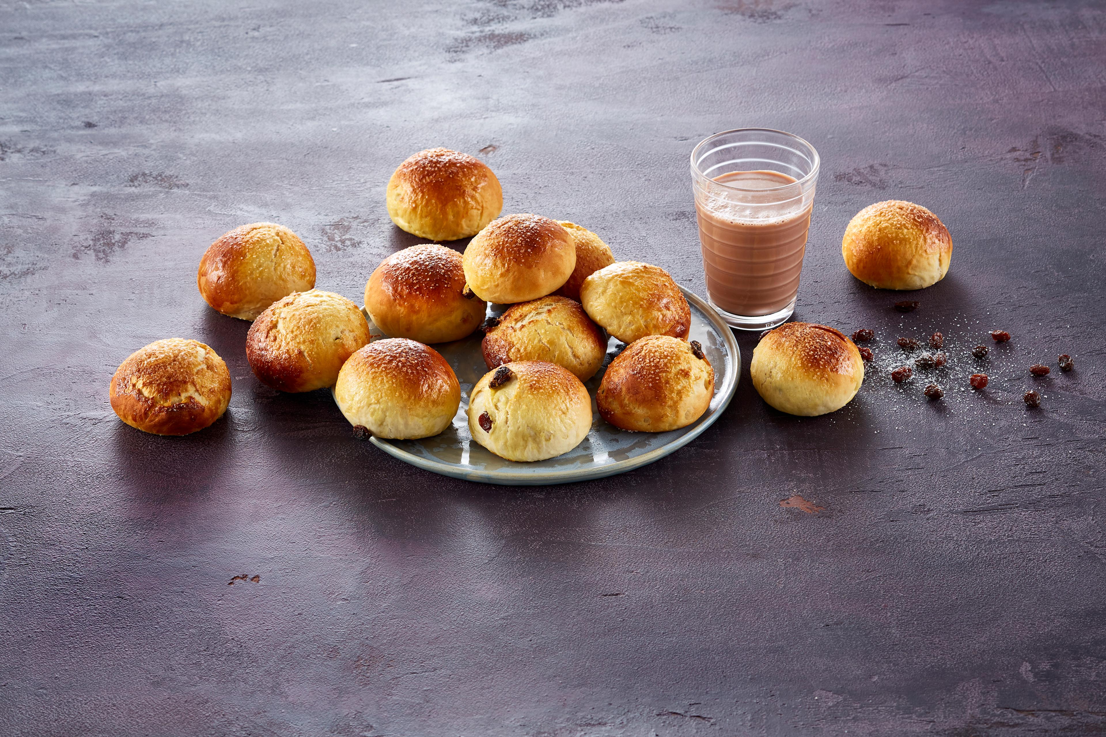 Et fat med sukkerboller ved siden av et glass sjokolademelk