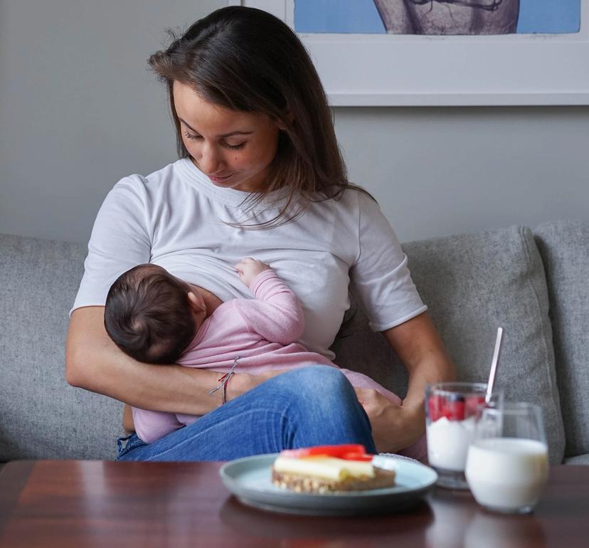 Dame som ammer barnet sitt