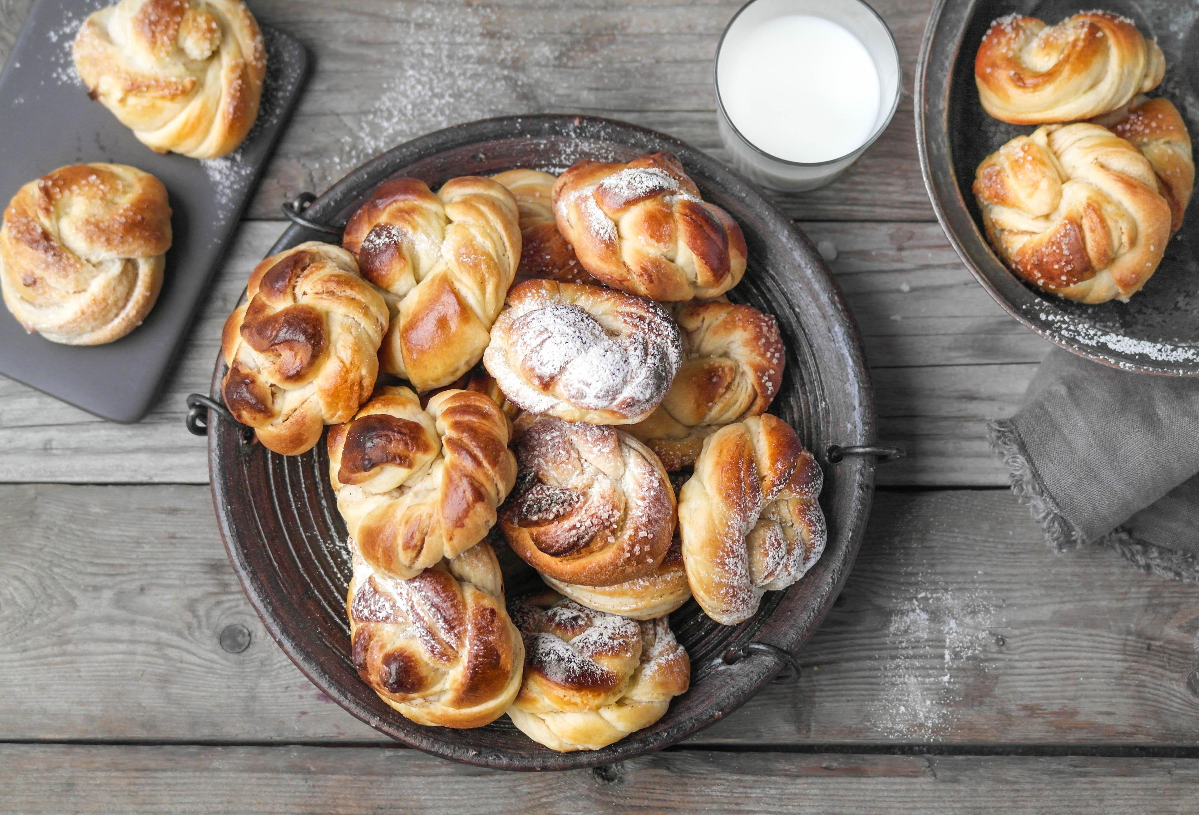 Et fat med kanelsnurrer og et glass melk