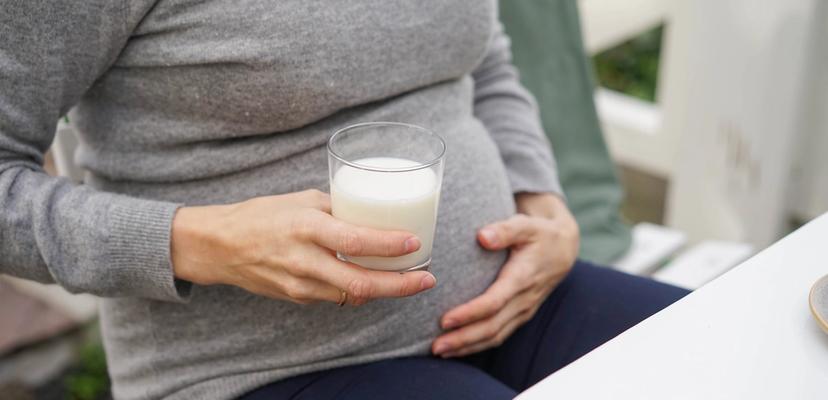 Gravid med et glass melk i hånden