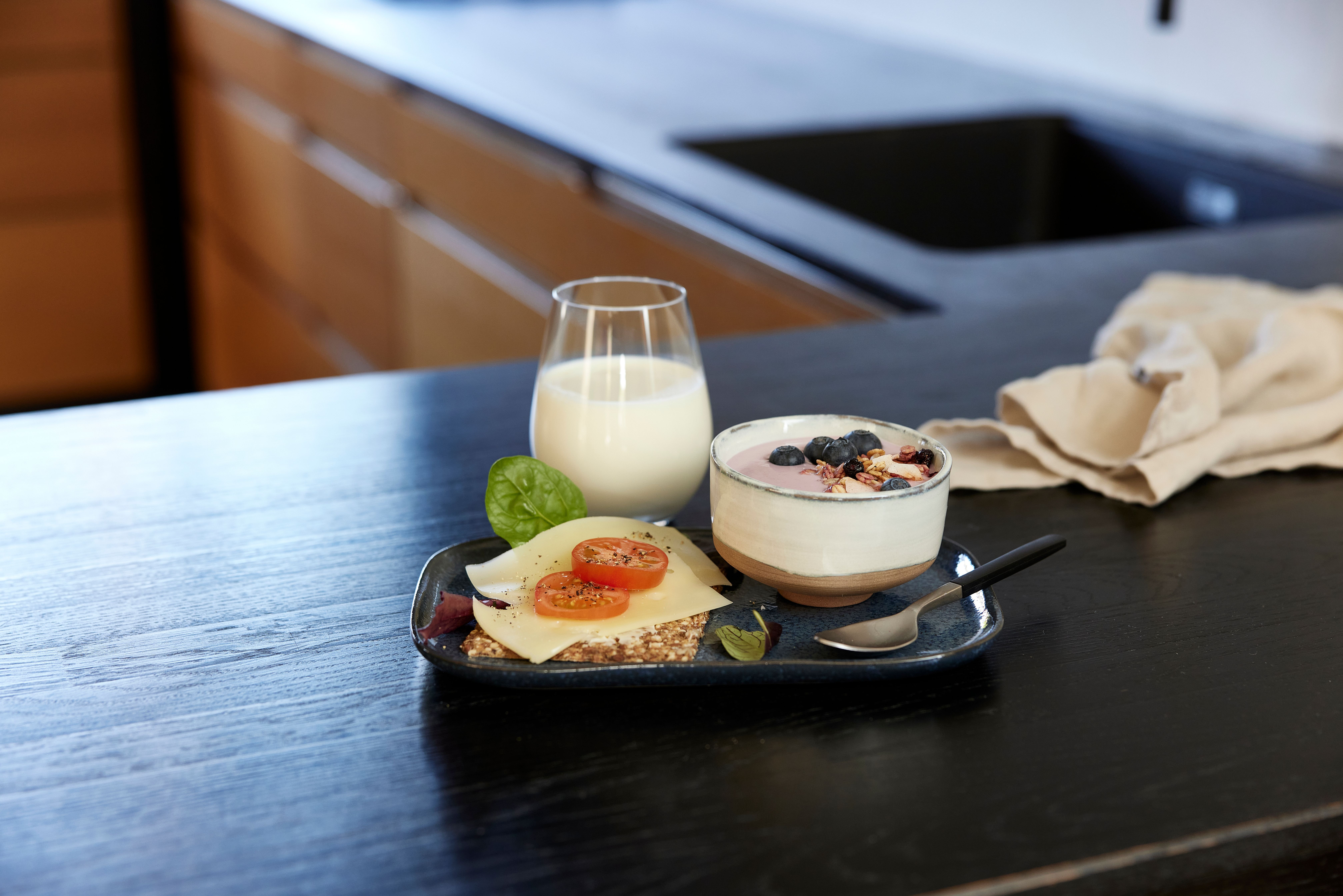 a tray of food and a glass of milk on a table .