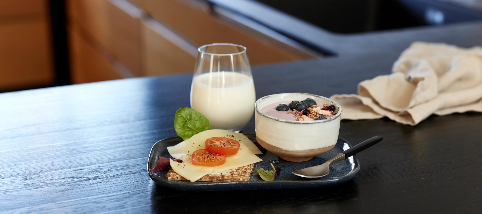 Smør, rømme i en skål og melk i en glassmugge