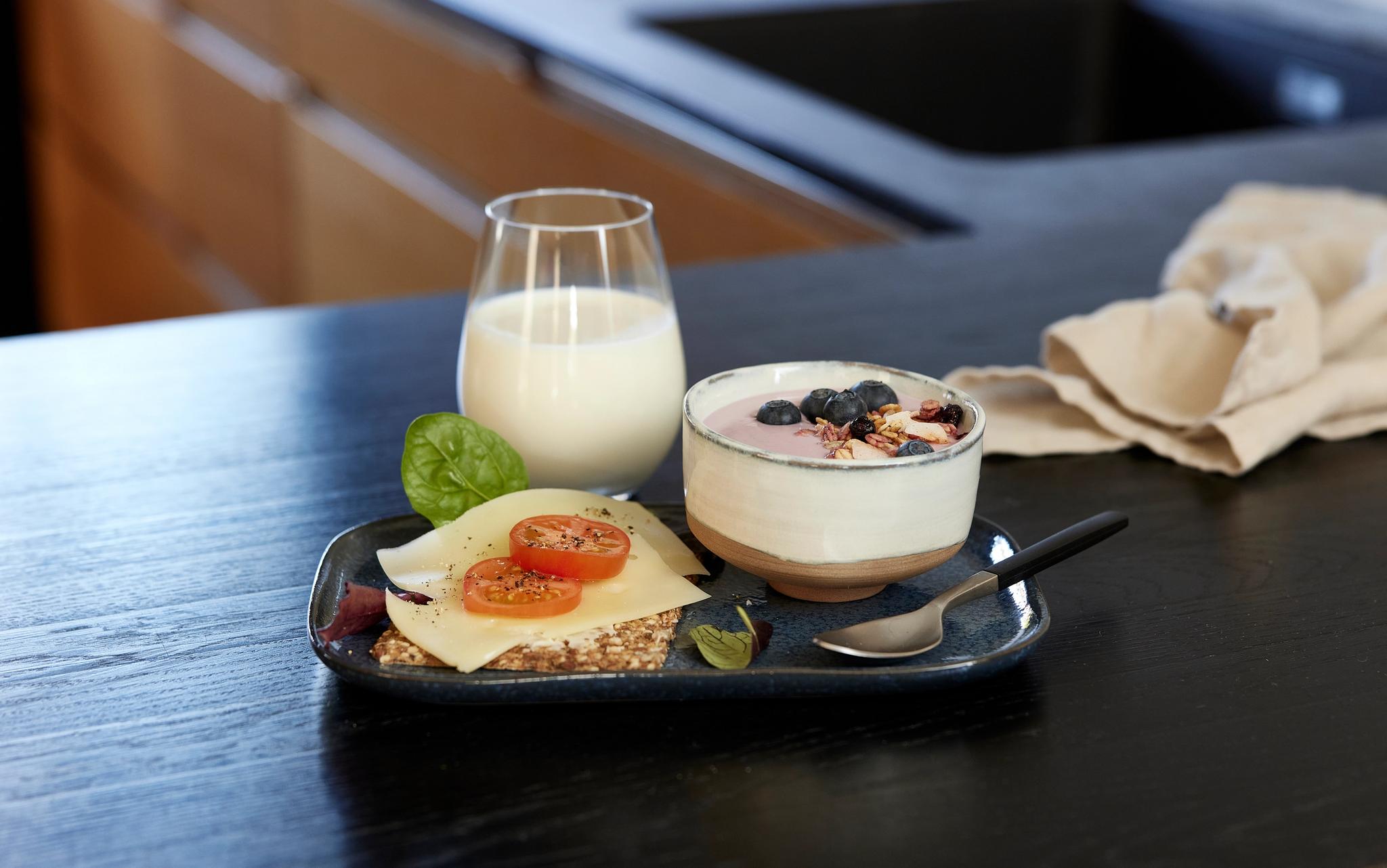 a tray of food and a glass of milk on a table .