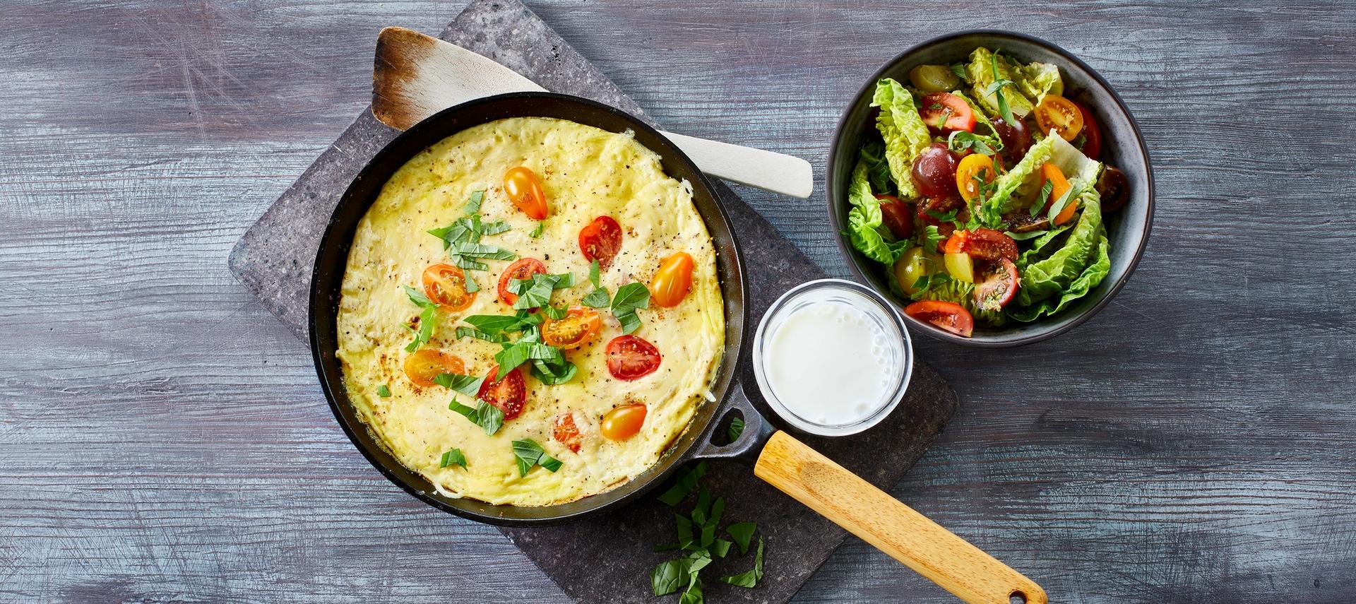 Omelett med tomat og grønn salat, og et glass melk