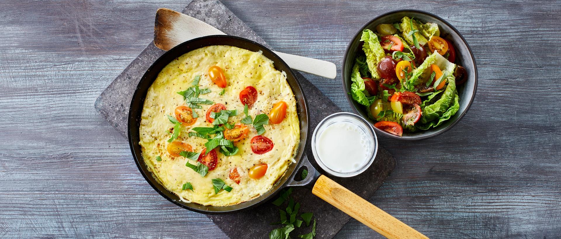 Omelett med tomat og grønn salat, og et glass melk