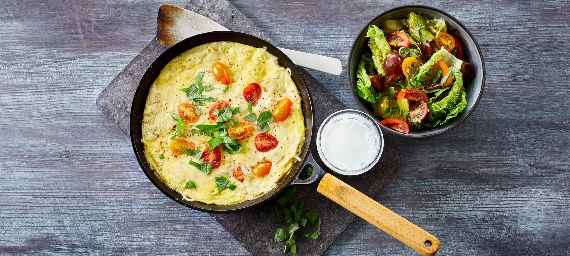 Omelett med tomat og grønn salat, og et glass melk
