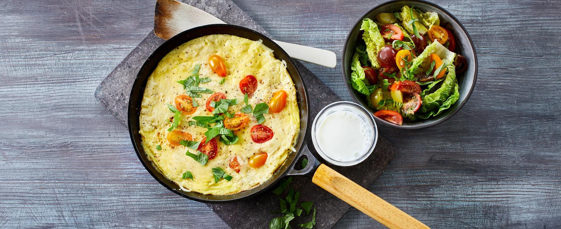 Omelett med tomat og grønn salat, og et glass melk
