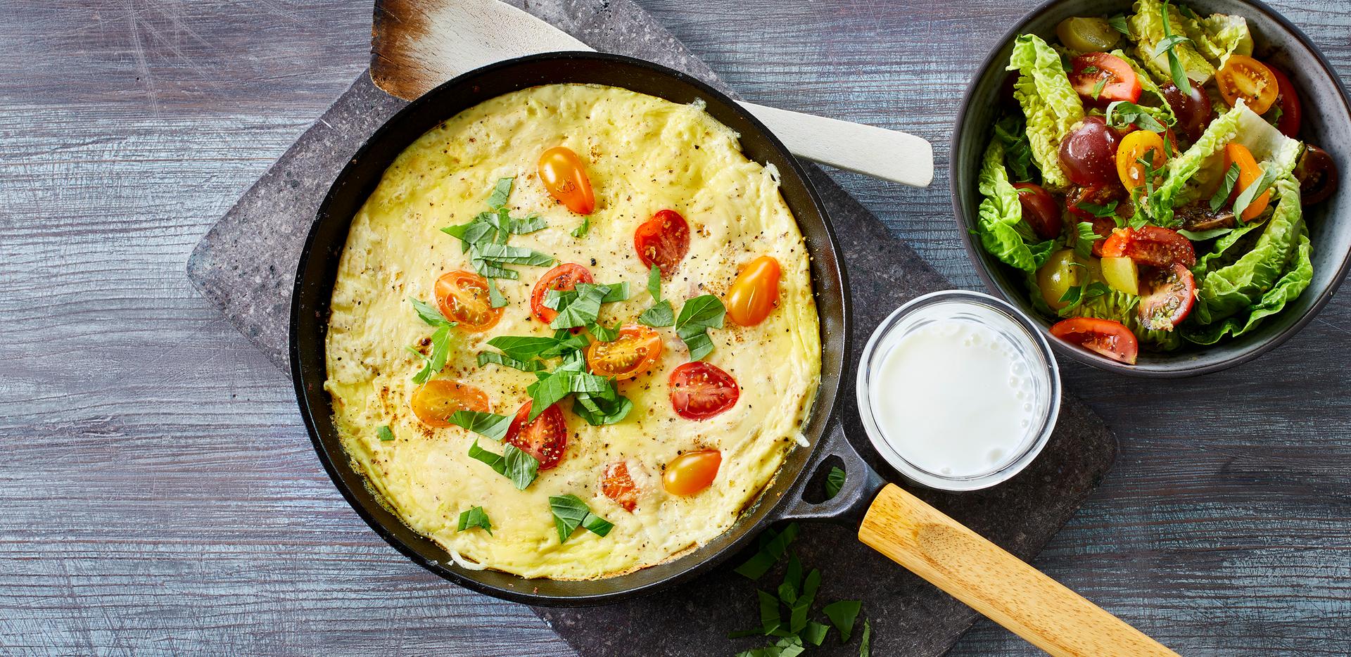Omelett med tomat og grønn salat, og et glass melk