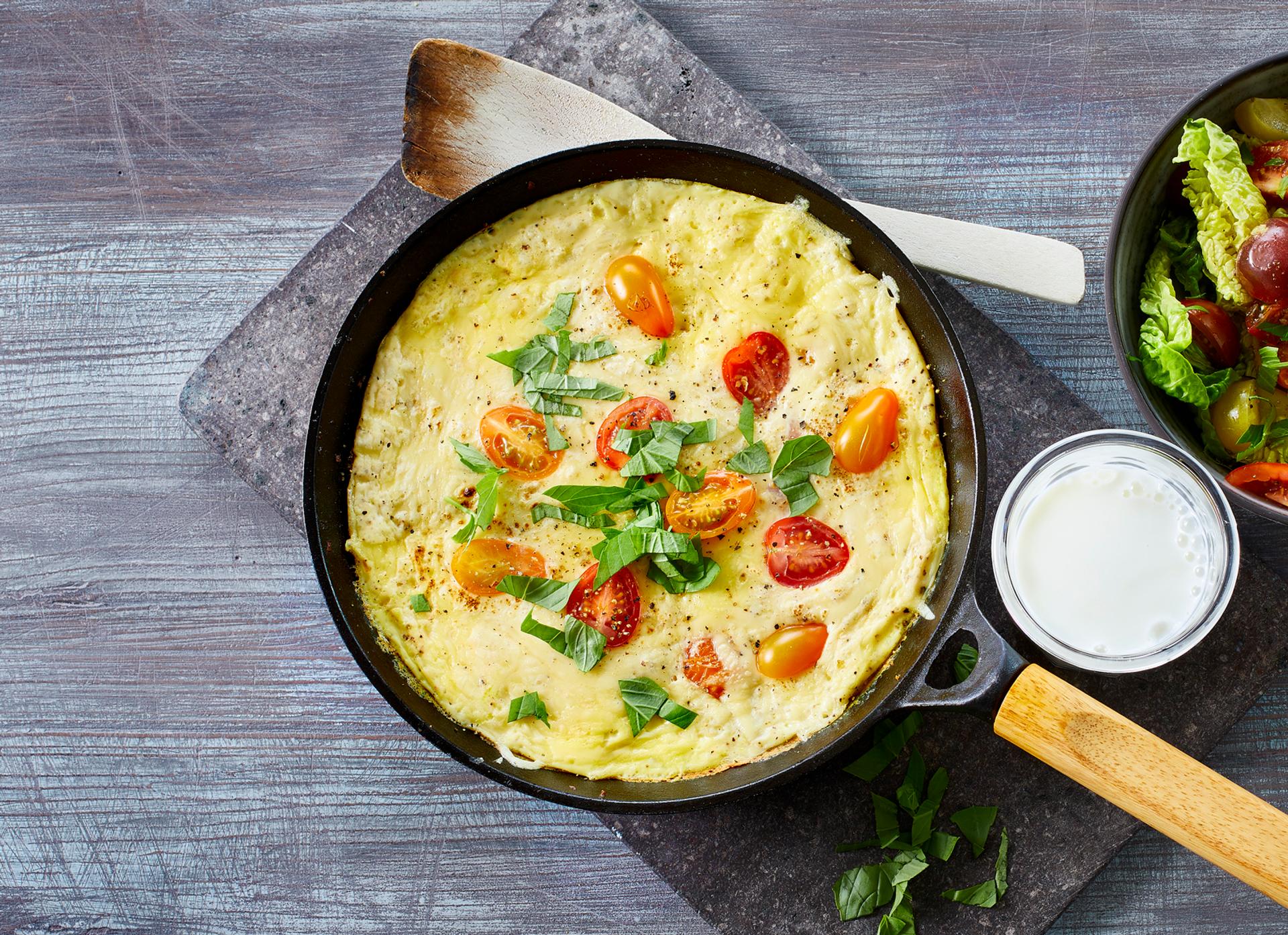 Omelett med tomat og grønn salat, og et glass melk