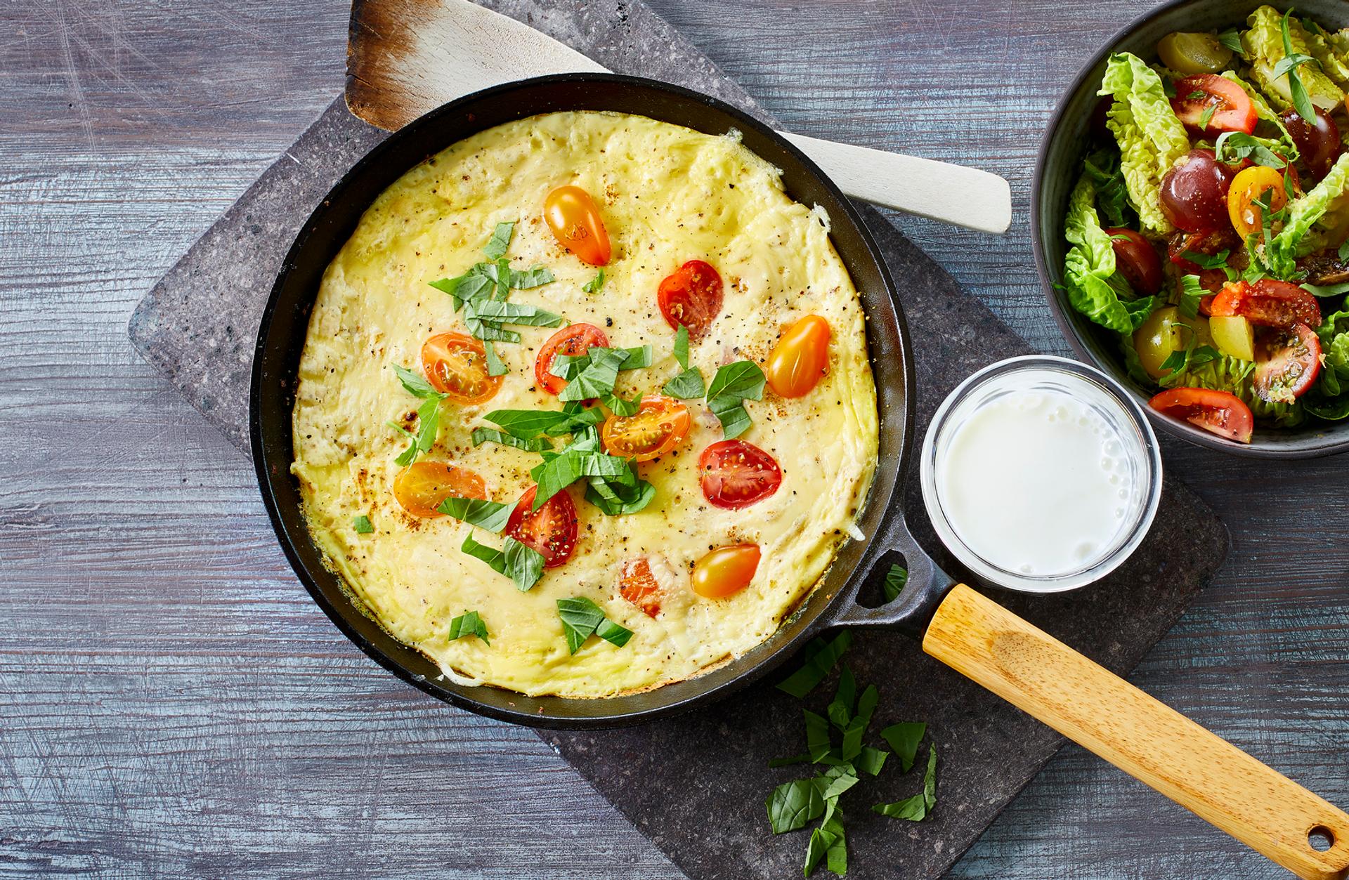Omelett med tomat og grønn salat, og et glass melk