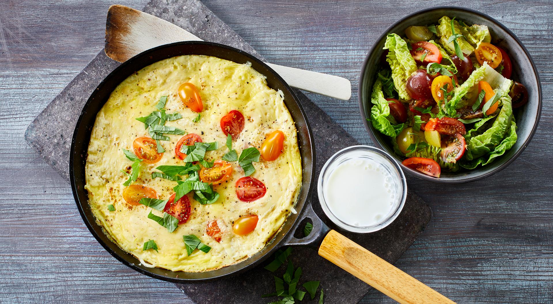 Omelett med tomat og grønn salat, og et glass melk