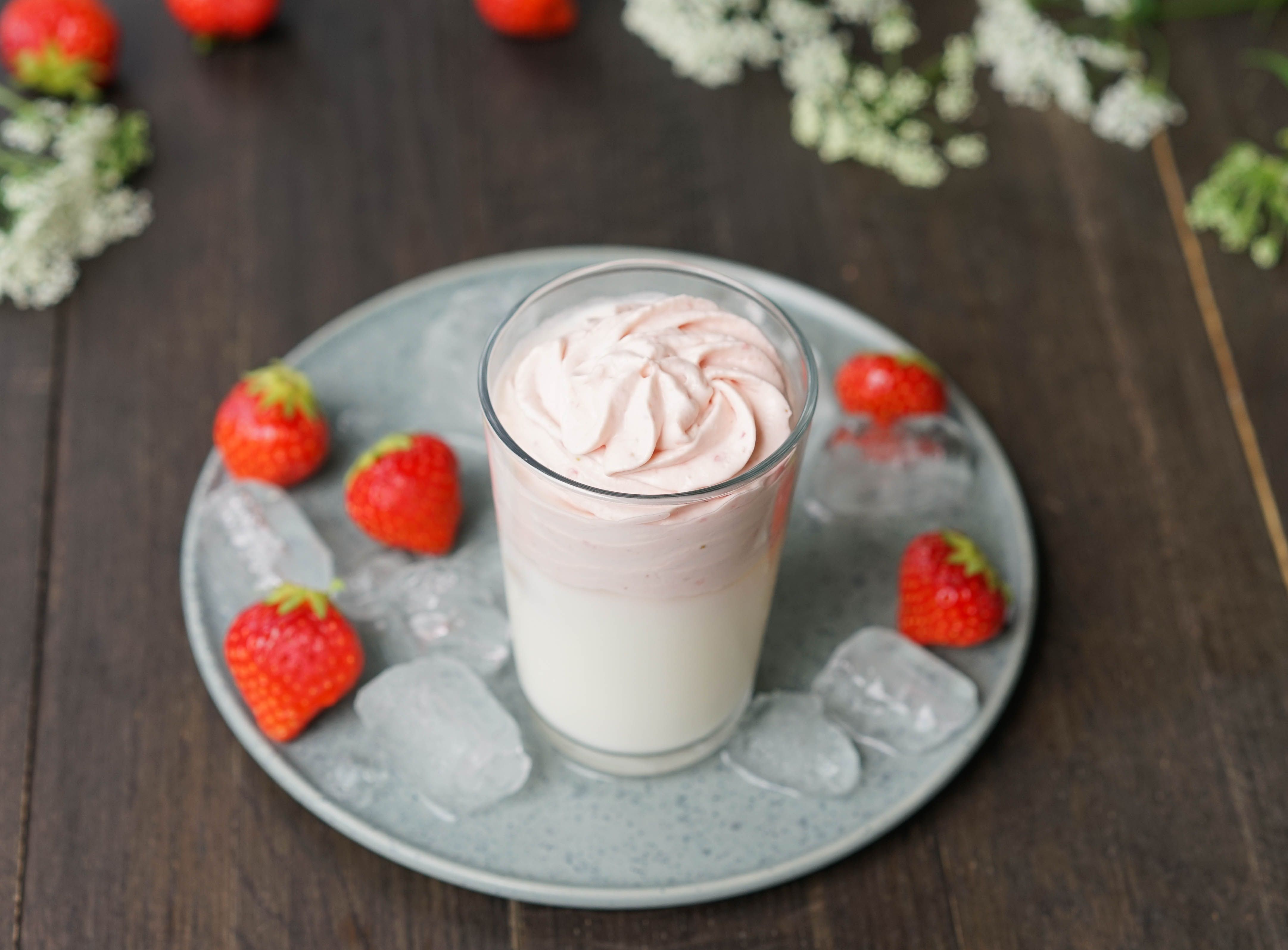 Dalgona med jordbær i høyt glass med jordbær rundt