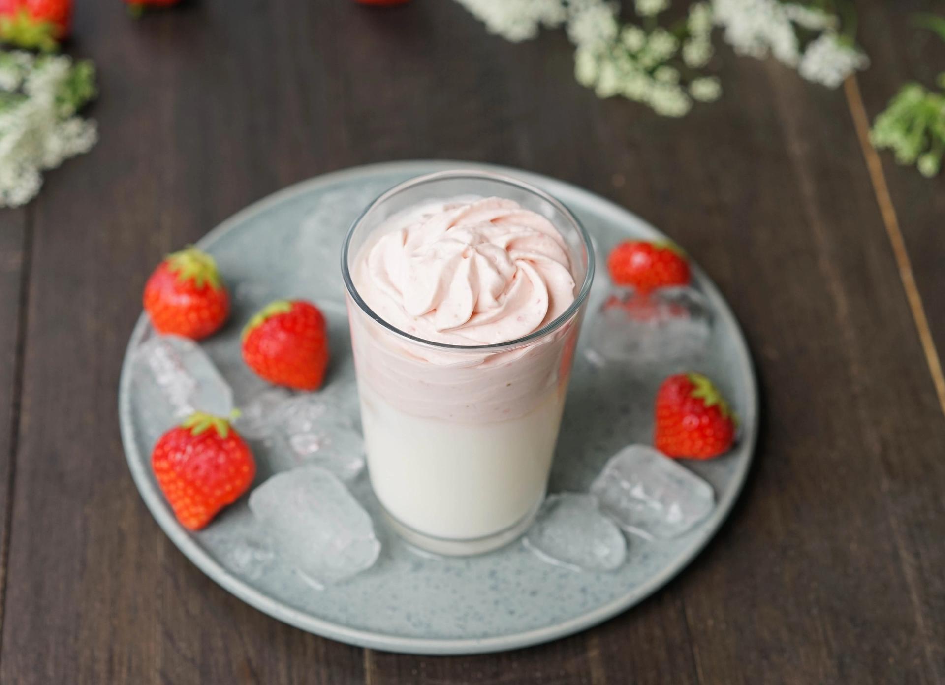 Dalgona med jordbær i høyt glass med jordbær rundt