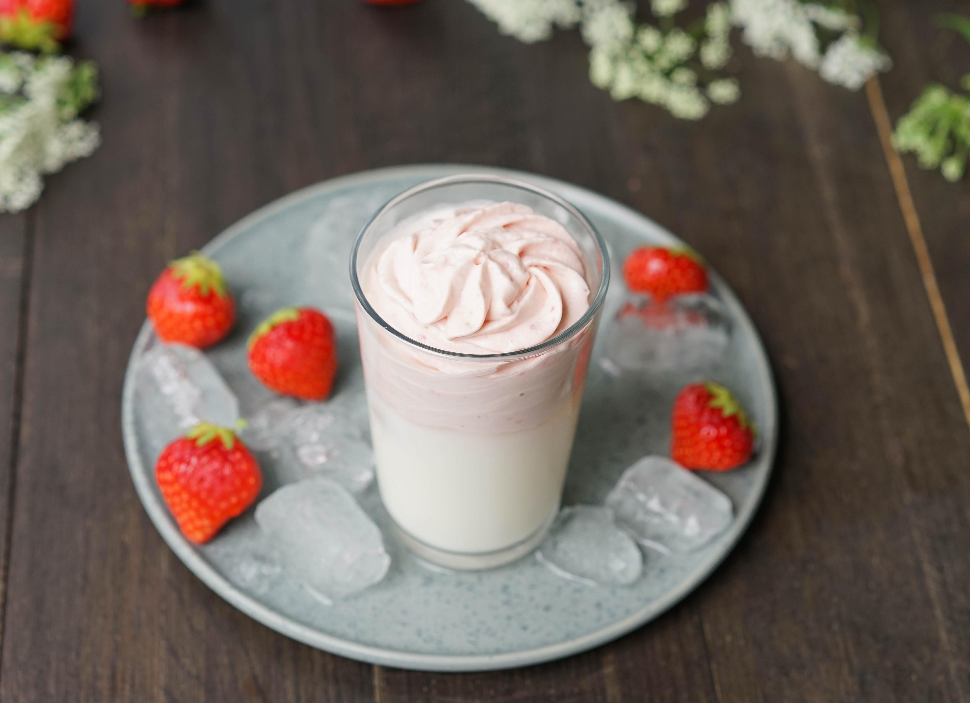 Dalgona med jordbær i høyt glass med jordbær rundt