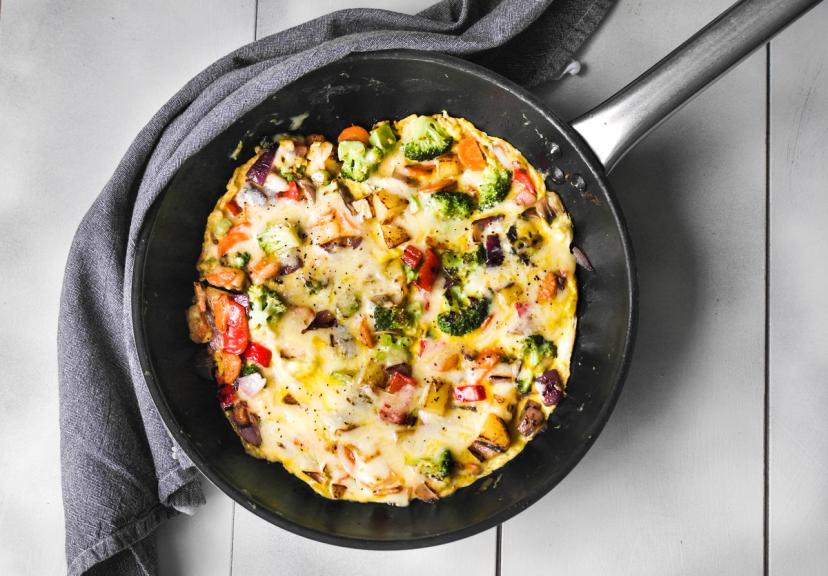 omelett med grønnsaker og ost i en stekepanne