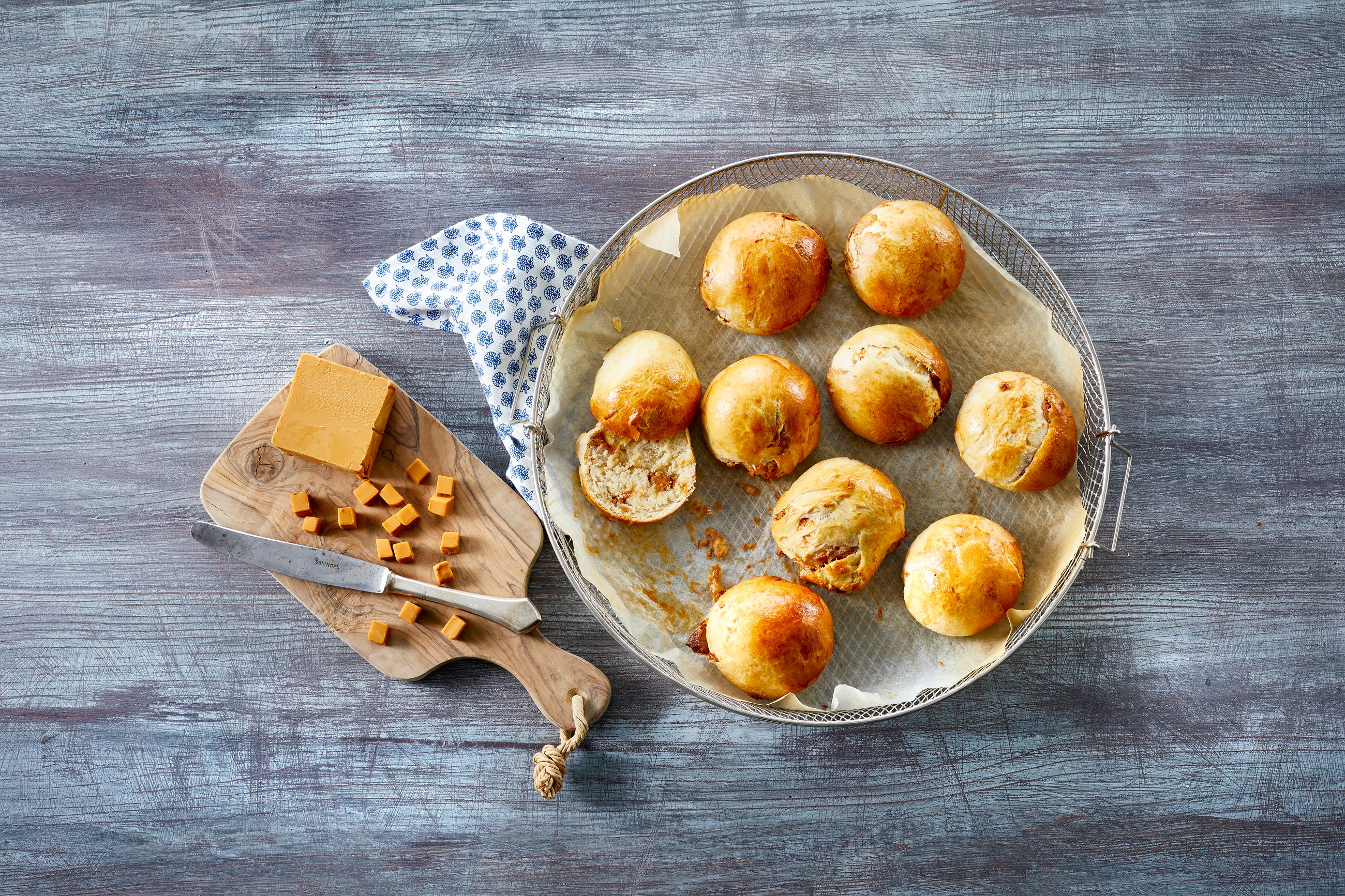 Brunostboller et på fat ved siden av brunost i terninger på en fjøl