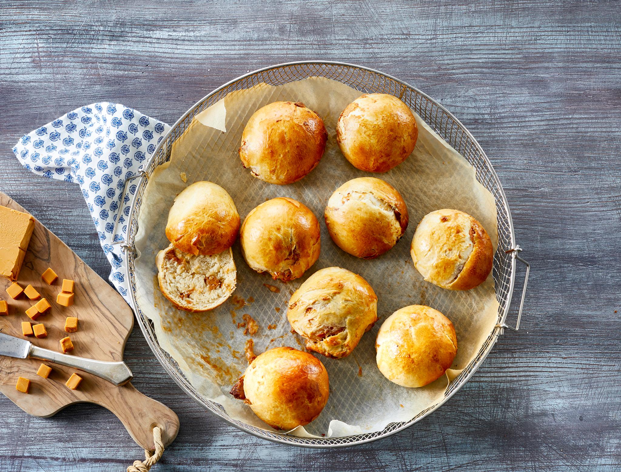 Brunostboller et på fat ved siden av brunost i terninger på en fjøl
