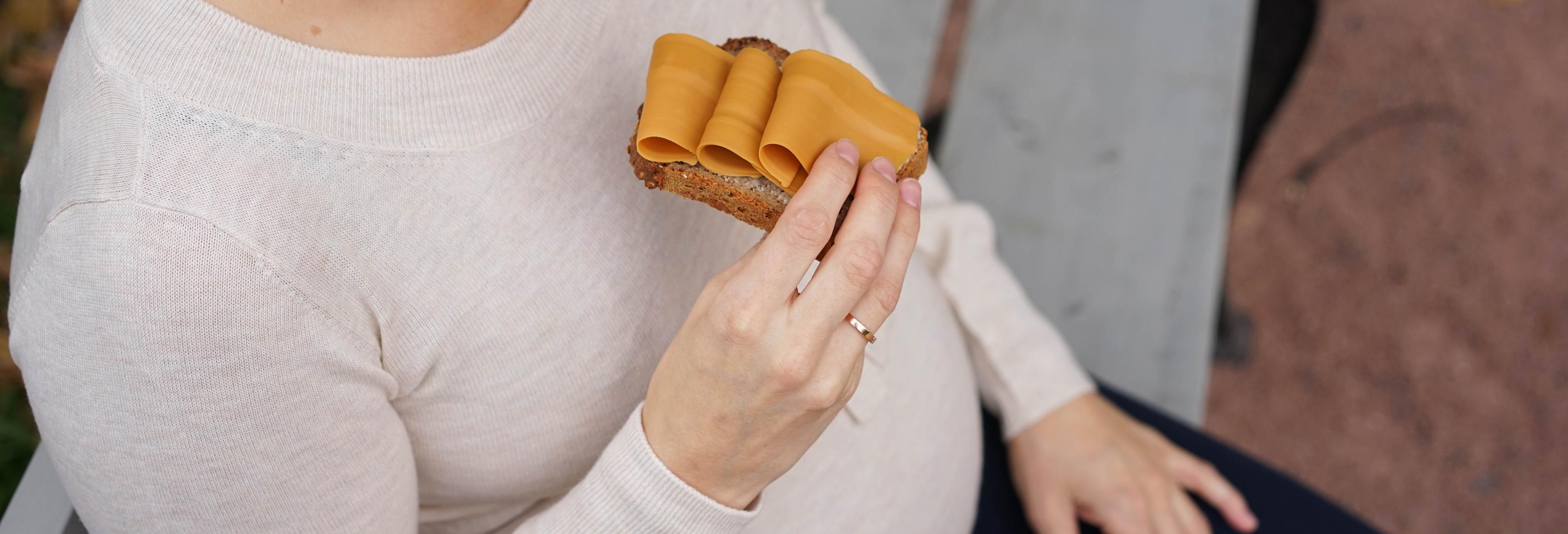 gravid kvinne spiser brød med brunost