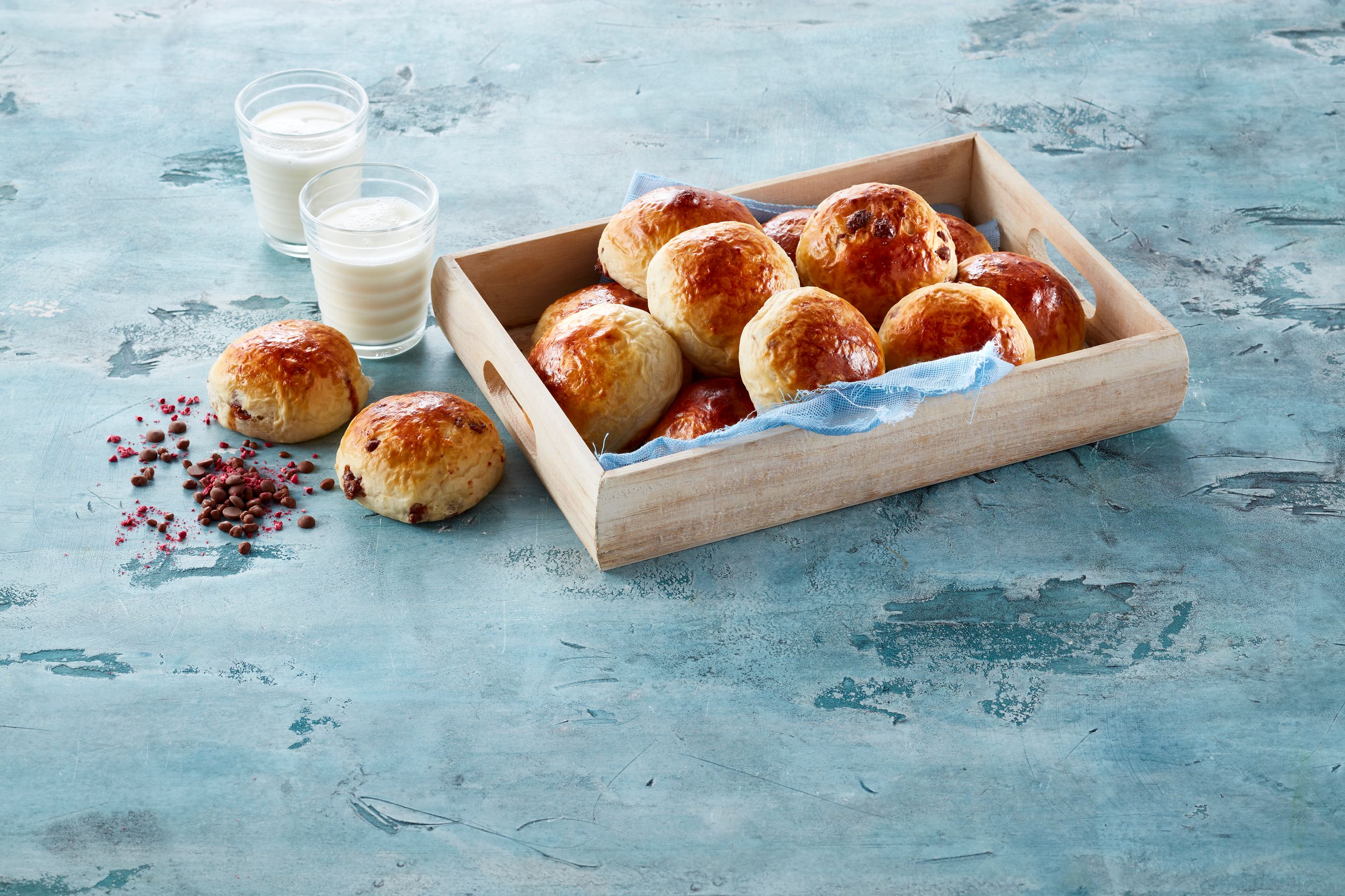 Et fat med nystekte sjokoladeboller og to glass melk