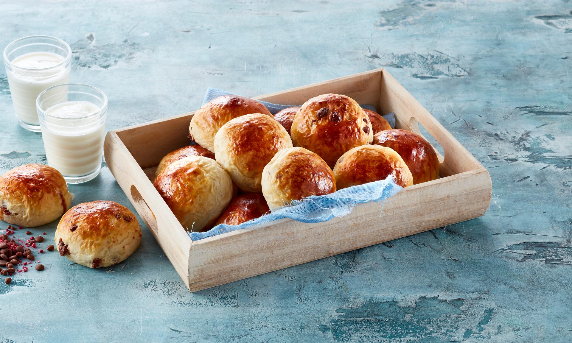 Et fat med nystekte sjokoladeboller og to glass melk