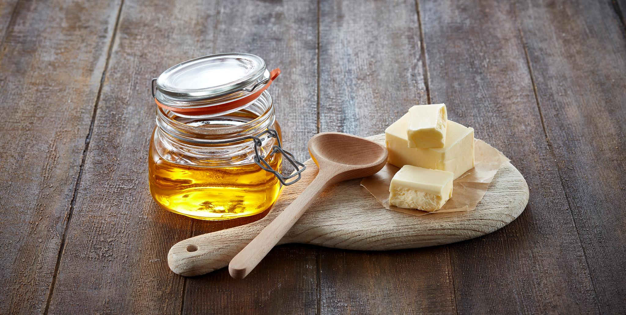 Krukke med ghee og noen smørklatter ved siden av