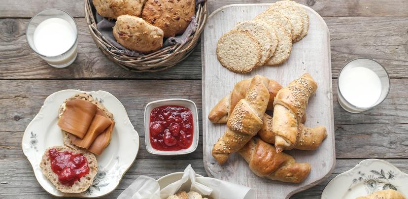 bord med scones, fylte horn, havrekjeks, syltetøy og melk
