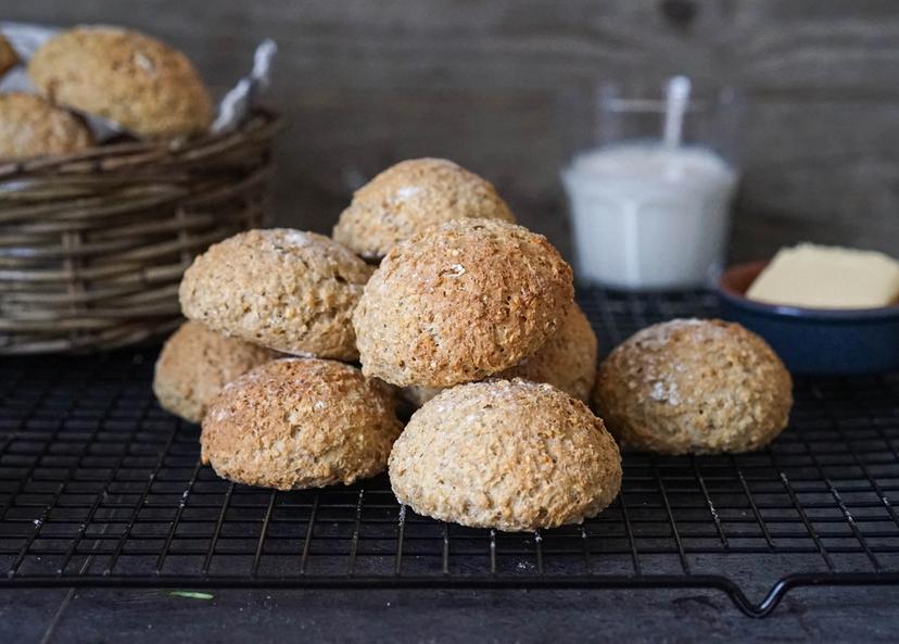 Grove rundstykker på rist med et glass melk i bakgrunnen