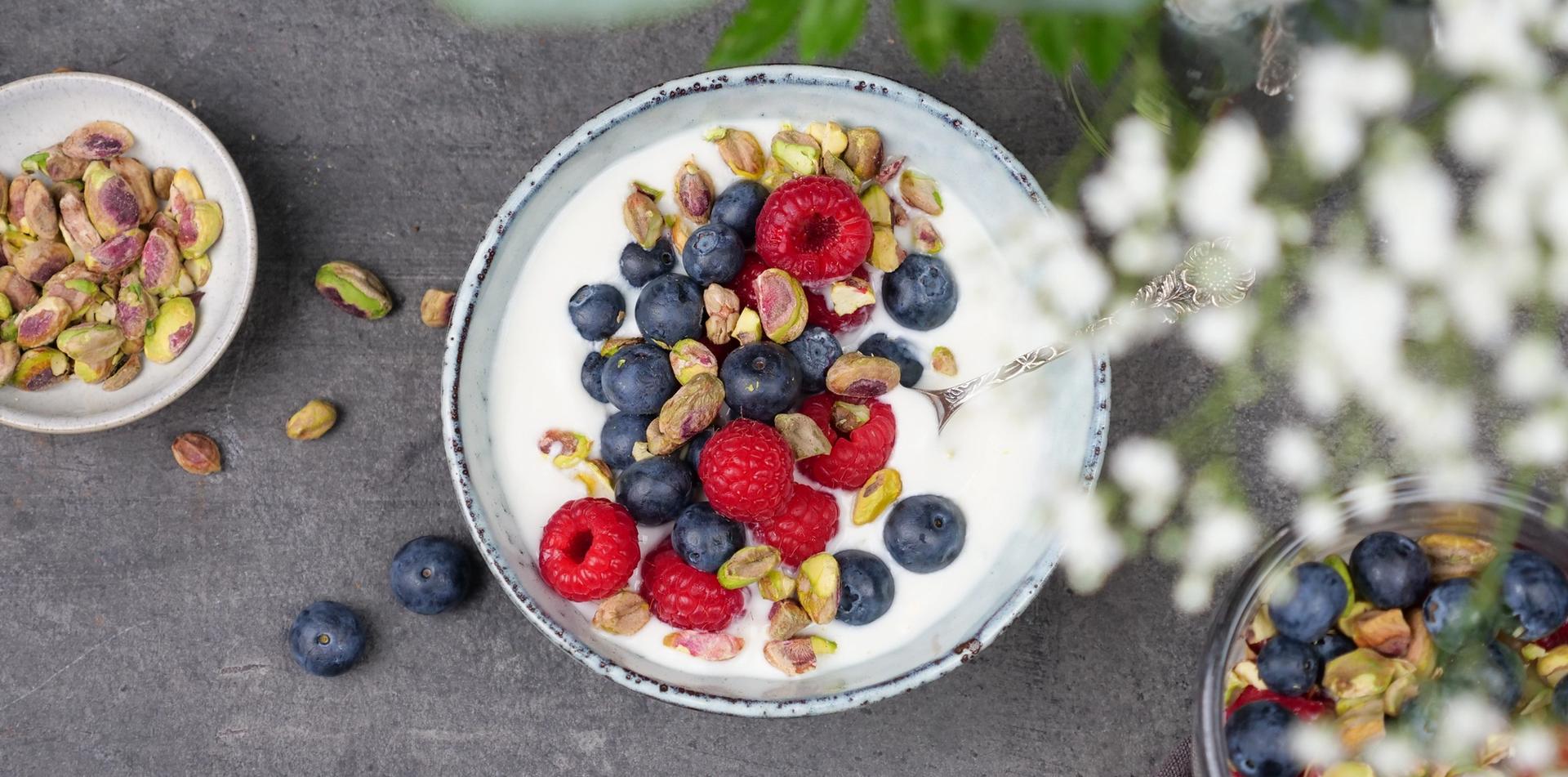 Skål med yoghurt, med bringebær, blåbær og pistasjenøtter